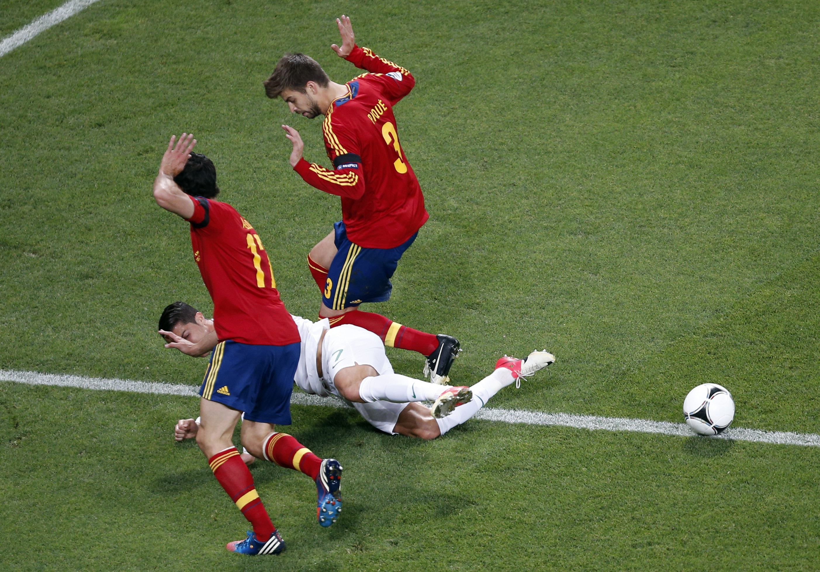 Portugal's Cristiano Ronaldo falls as he is flanked by Spain's Gerard Pique, right, and Alvaro Arbeloa during the Euro 2012 soccer championship semifinal match between Spain and Portugal in Donetsk, Ukraine, Wednesday, June 27, 2012. (AP Photo/Darko Vojin