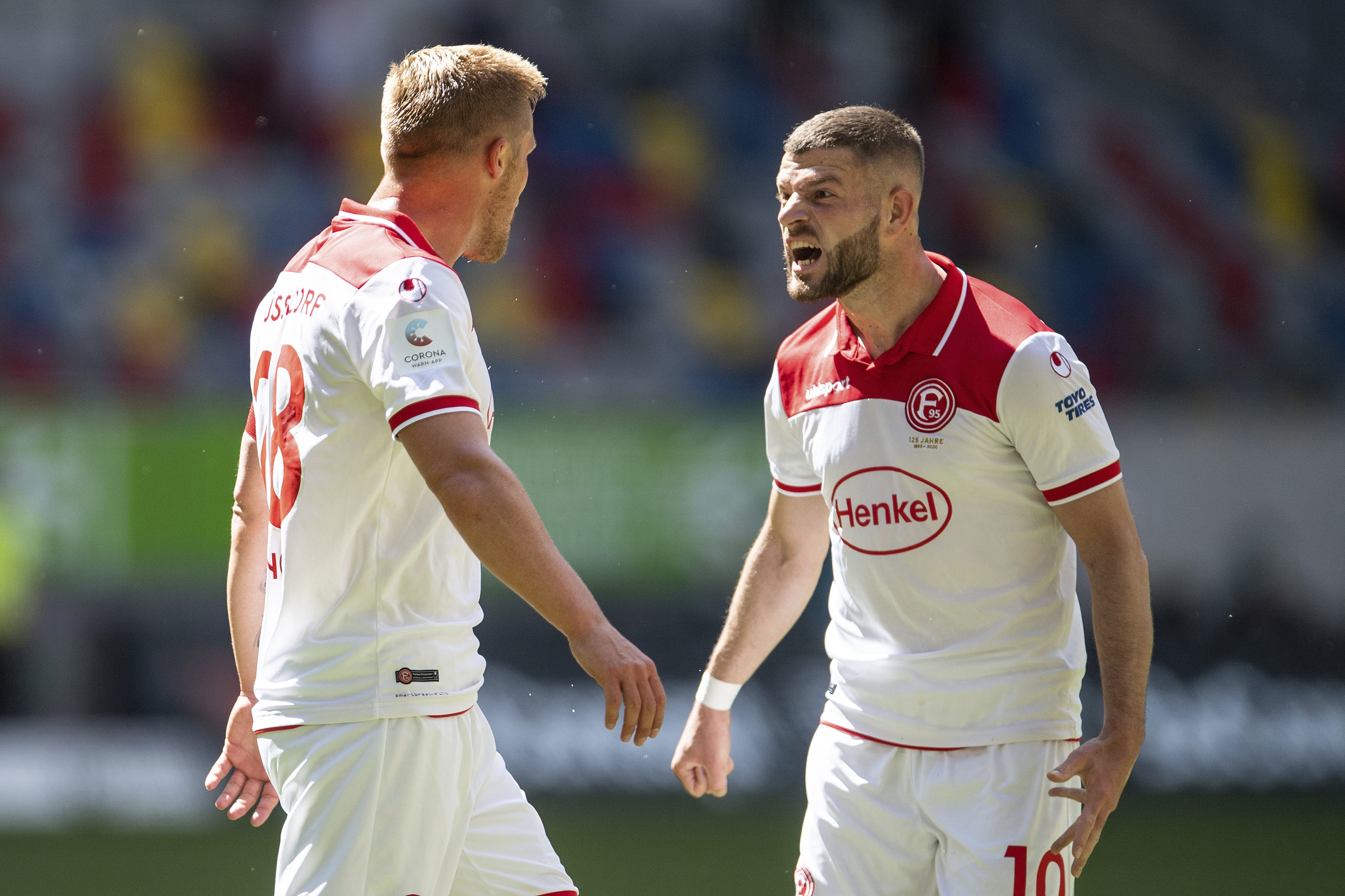 Duesseldorf's Rouwen Hennings, left, celebrates with Valon Berisha after he scores his side first goal during the German Bundesliga soccer match between Fortuna Duesseldorf and FC Augsburg in Duesseldorf, Germany, Saturday, June 20, 2020. (Marius Becker/P
