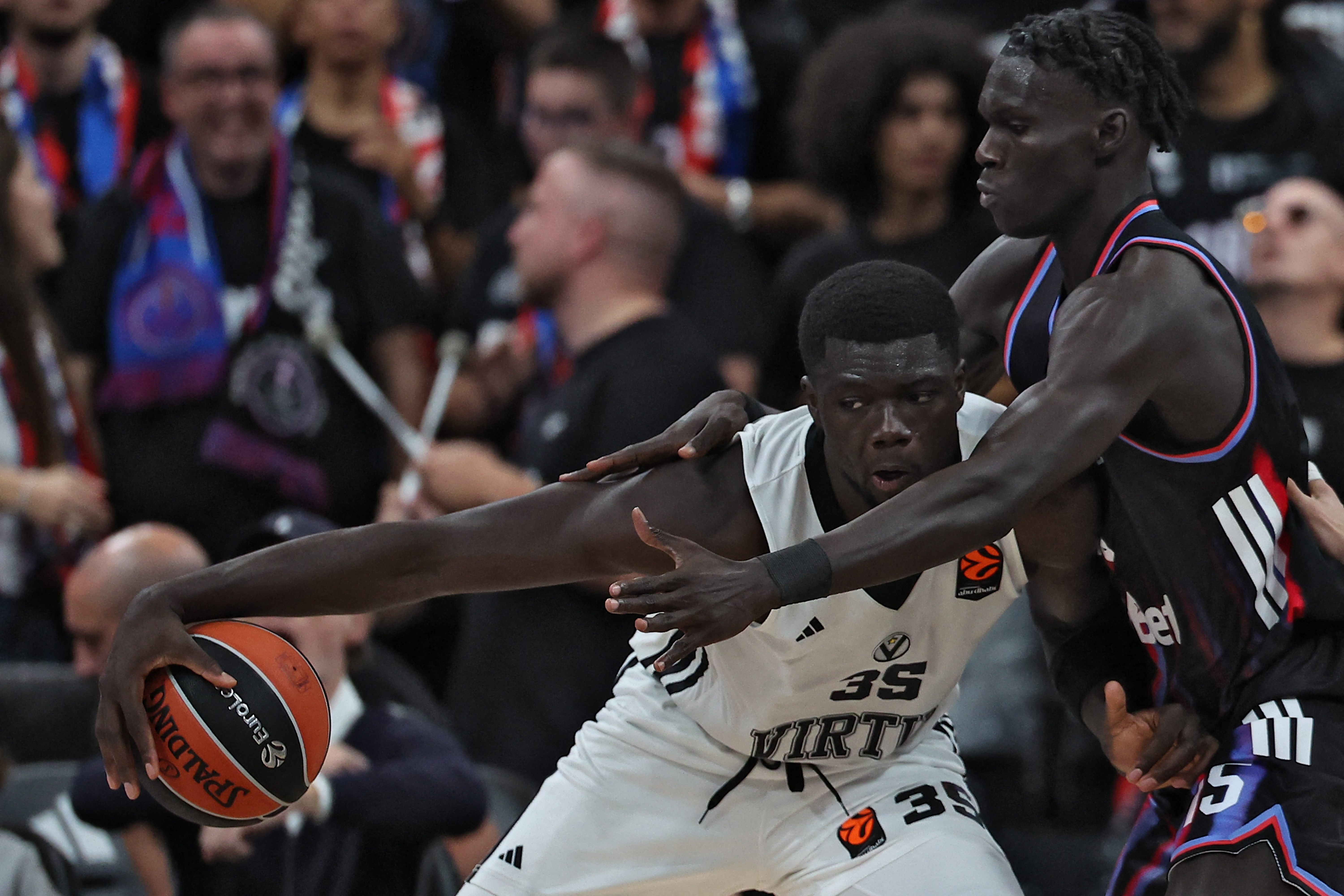 Bologna's Italian center Mouhamet Diouf (L) fights for the ball with Paris Basketball's
