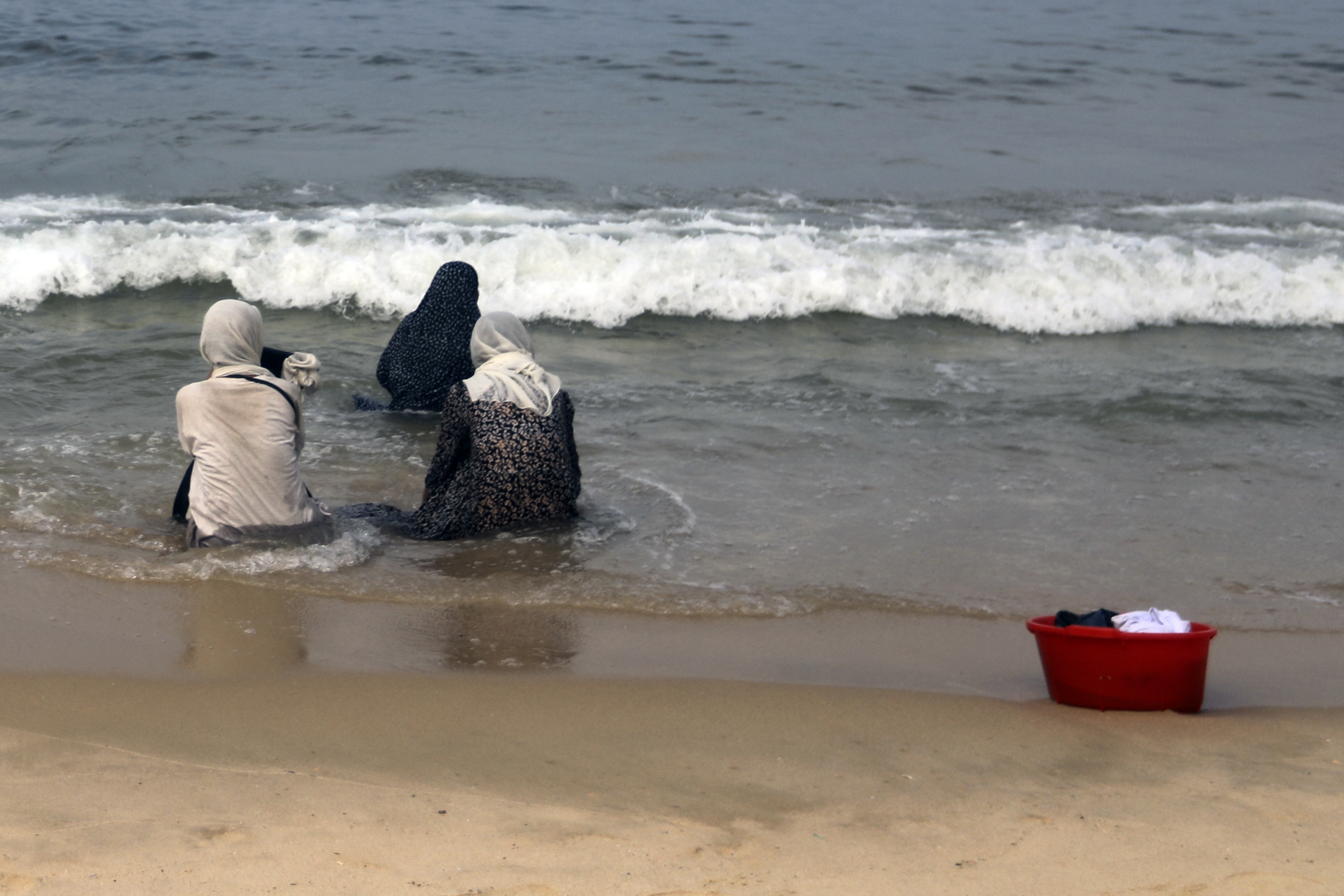 Palestinians resort to the sea water to bathe
