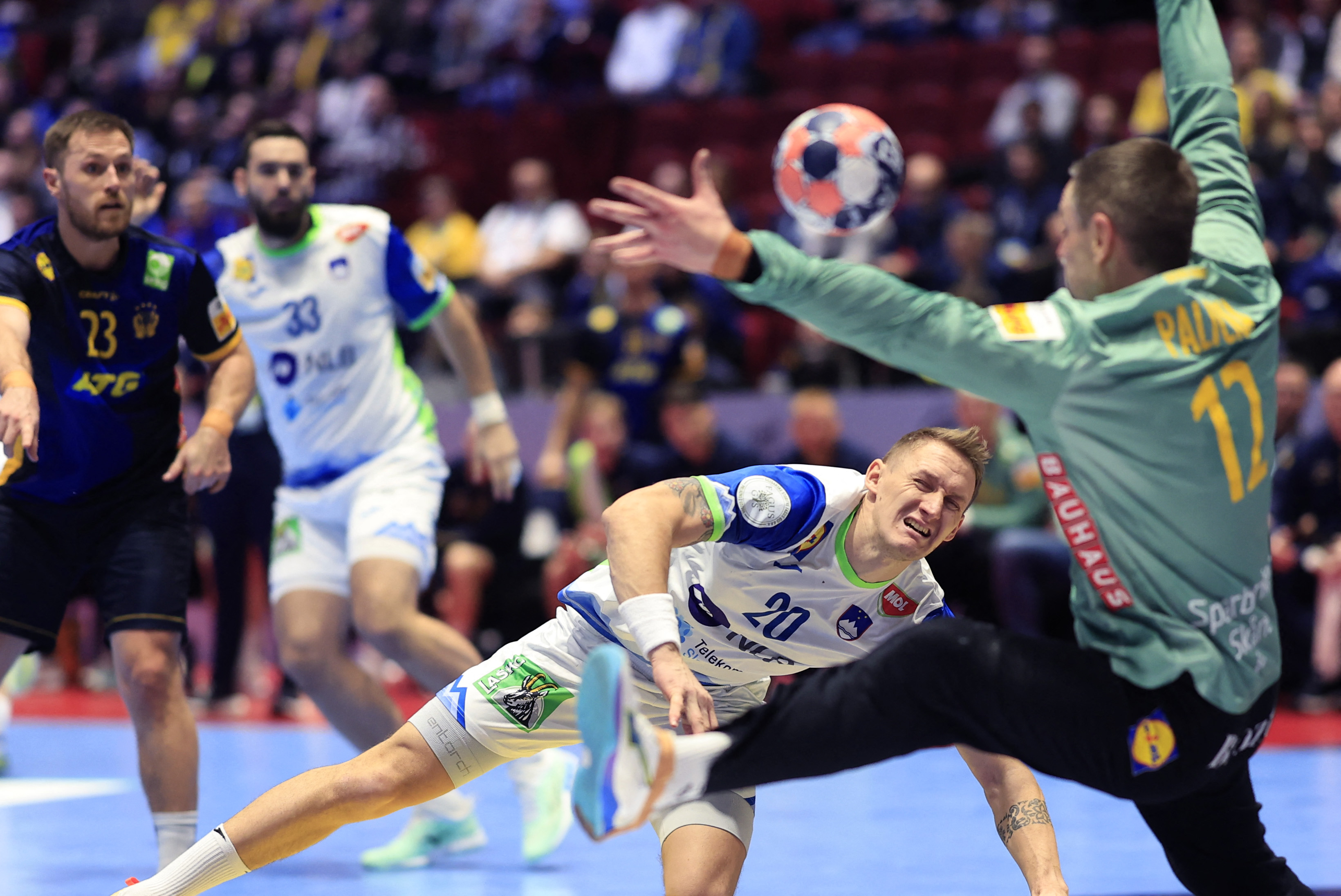 Slovenia's wing #20 Tilen Kodrin shoots against Sweden's goalkeeper #12 Andrea