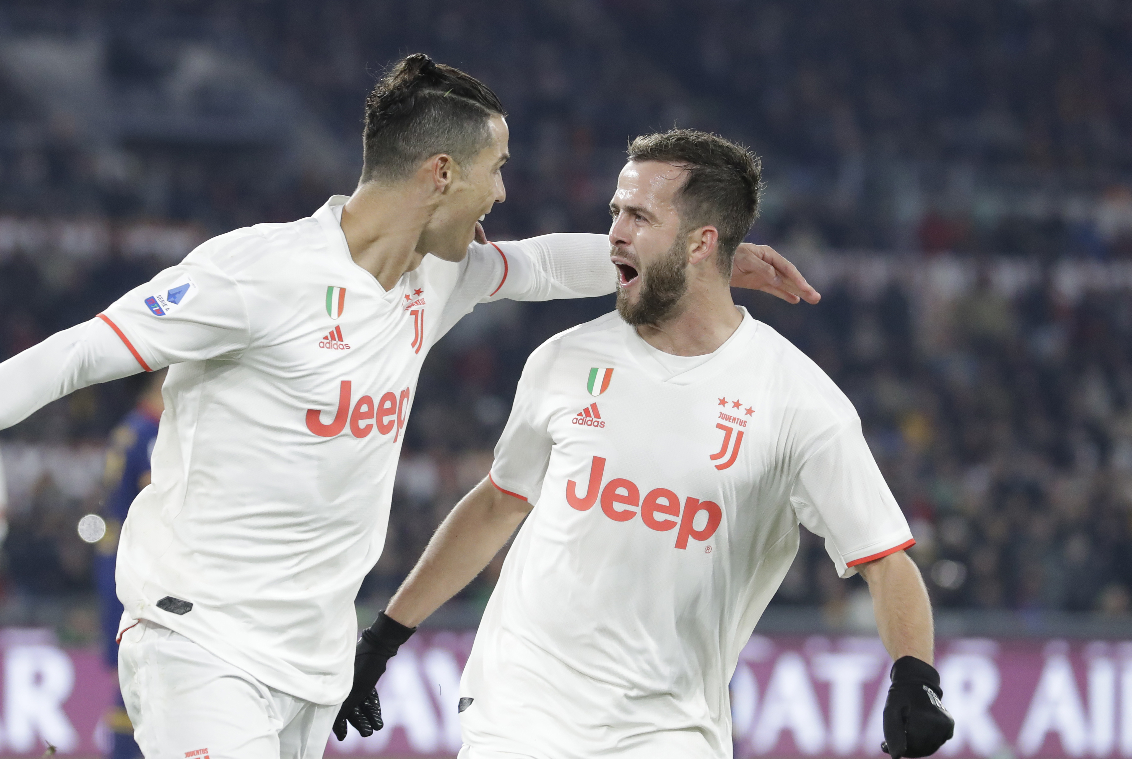 Juventus' Cristiano Ronaldo, left, celebrates with teammate Miralem Pjanic after scoring his side's second goal during the Serie A soccer match between Roma and Juventus at the Rome Olympic Stadium, Italy, Sunday, Jan. 12, 2020. (AP Photo/Andrew Medichini