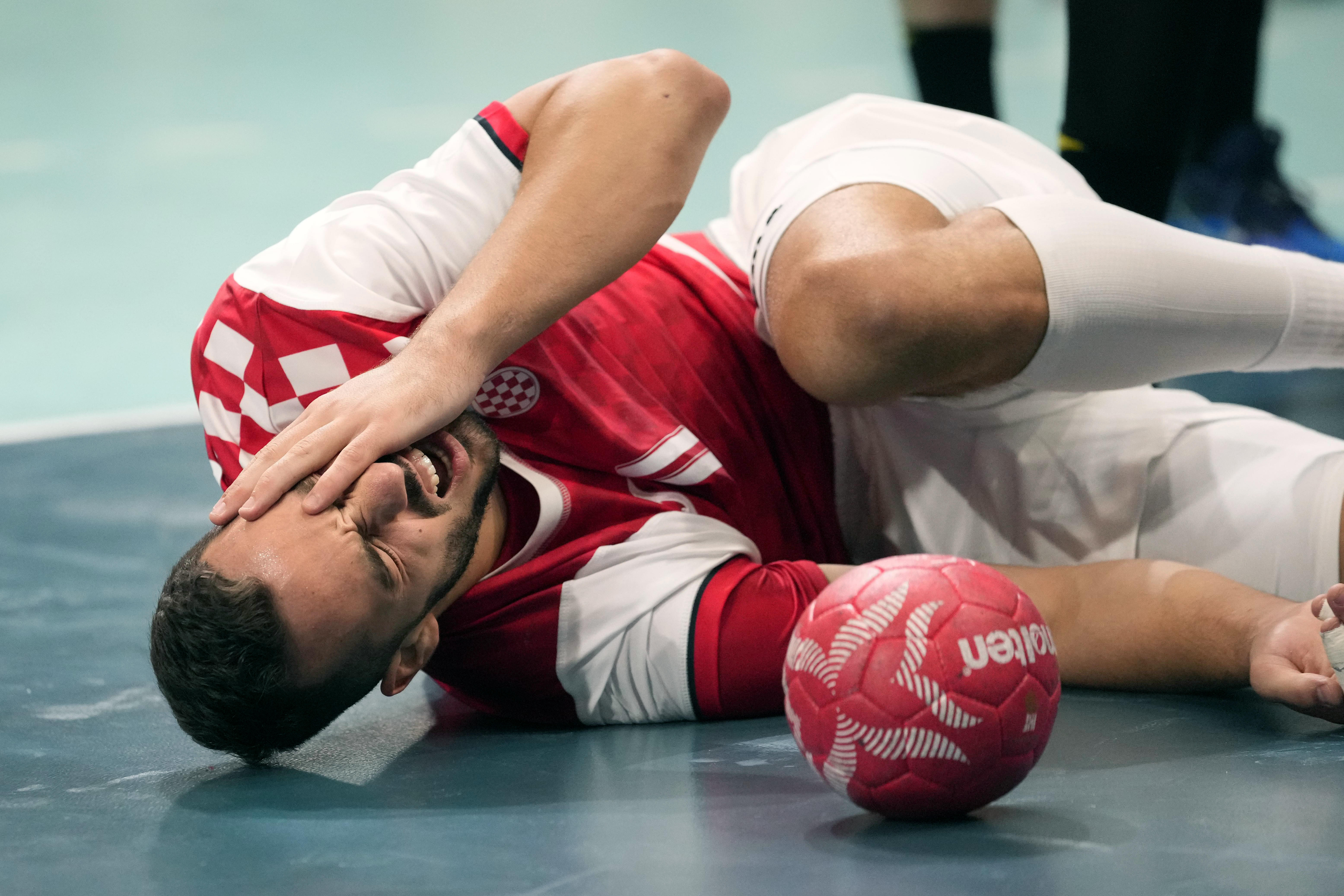 Zvonimir Srna, of Croatia, grimaces in pain during a men's handball match between Spain and Croatia at the 2024 Summer Olympics, Sunday, Aug. 4, 2024, in Paris, France. (AP Photo/Brian Inganga)