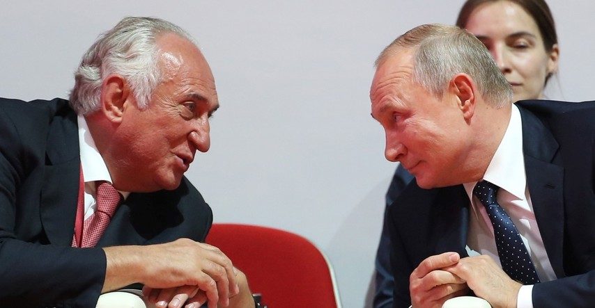A candid photo of two men in formal attire engaged in a conversation at an event, dated 2026-10-20.