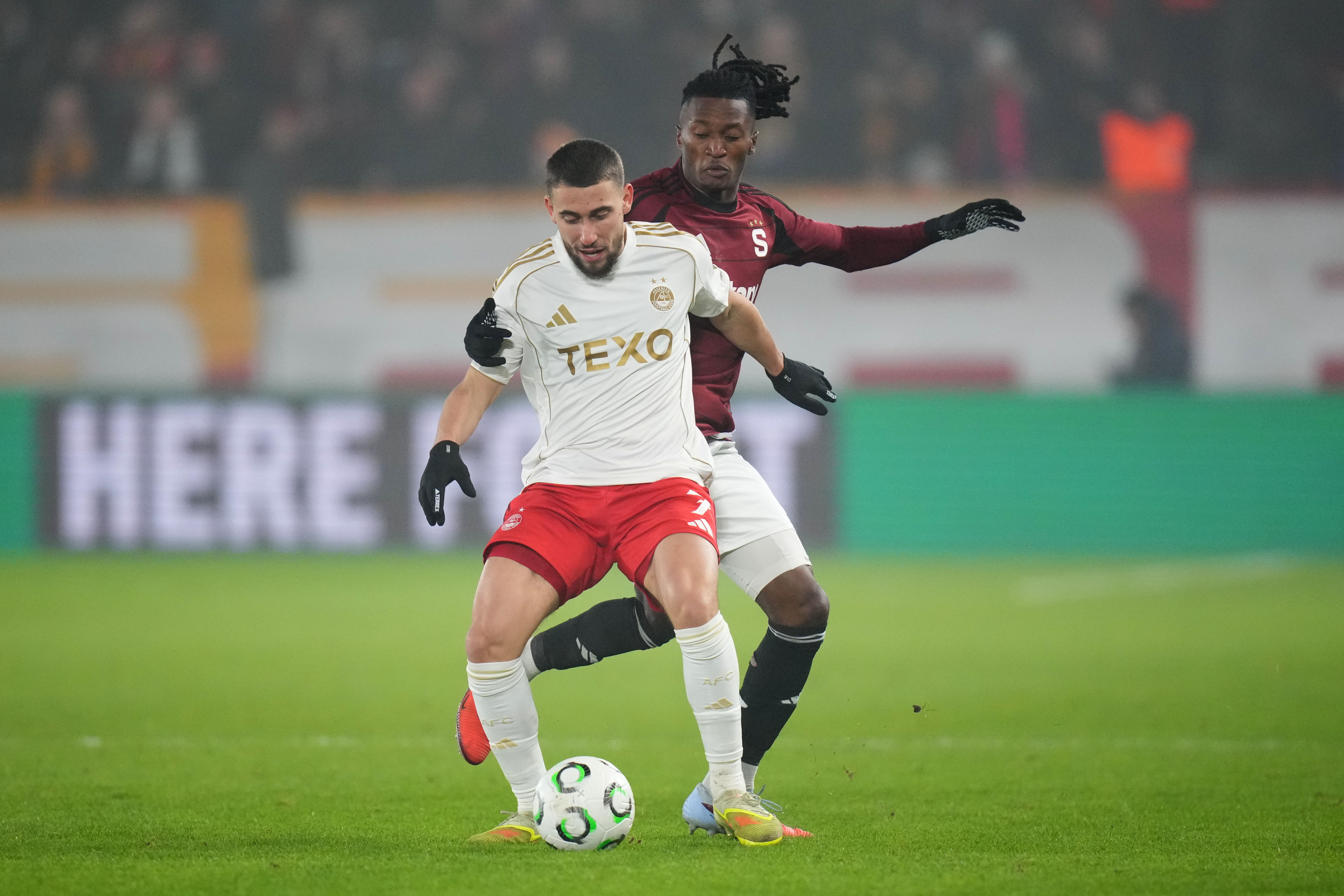 Aberdeen's Adil Aouchiche, front, duels for the ball with Sparta's Santiago Eneme during the Europa Conference League opening phase soccer match between Sparta Prague and Aberdeen in Prague, Czech Republic, Thursday, Dec. 18, 2025. (AP Photo/Petr David Jo