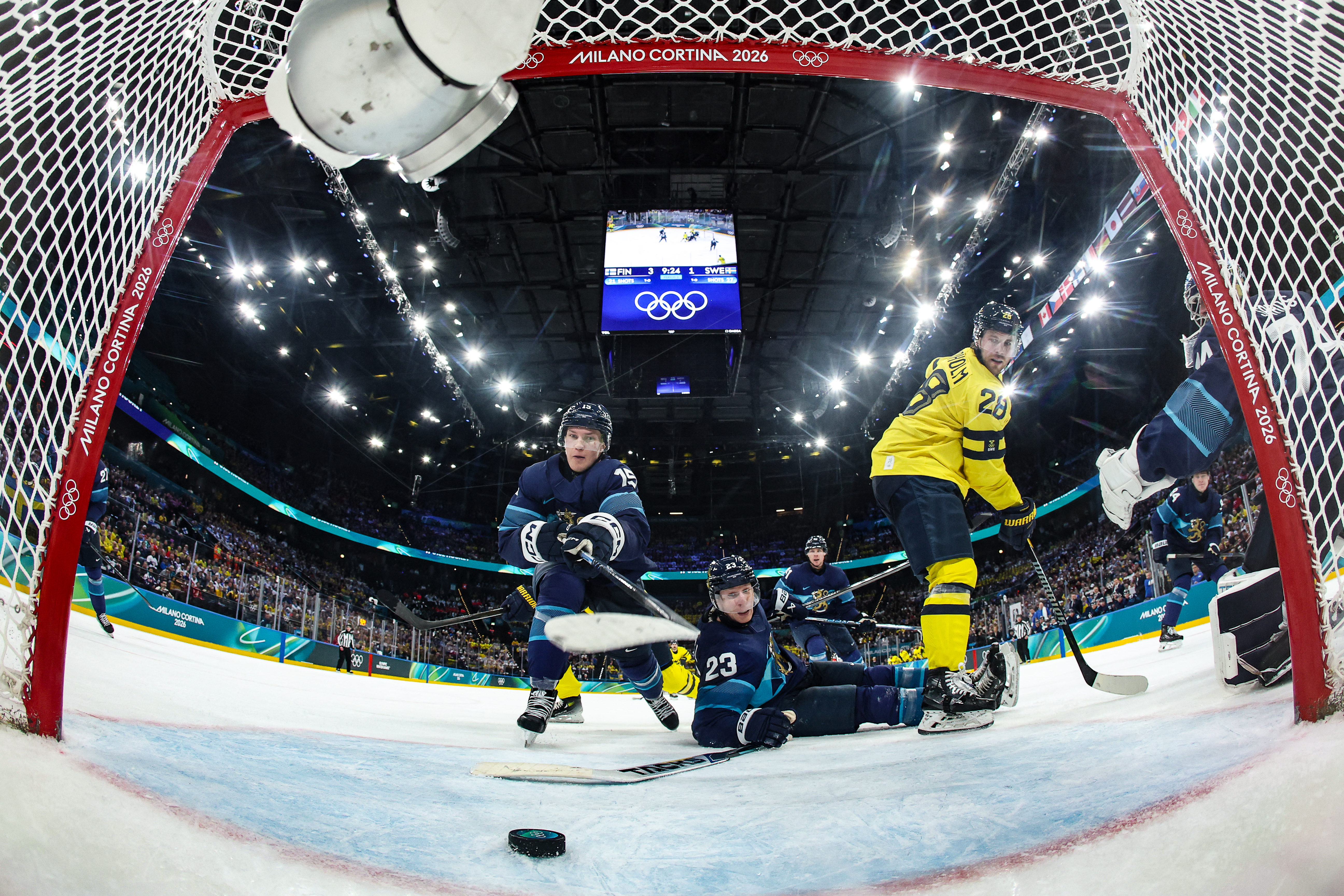 Finland's #15 Anton Lundell (L) saves a shot during the men's preliminary round Group