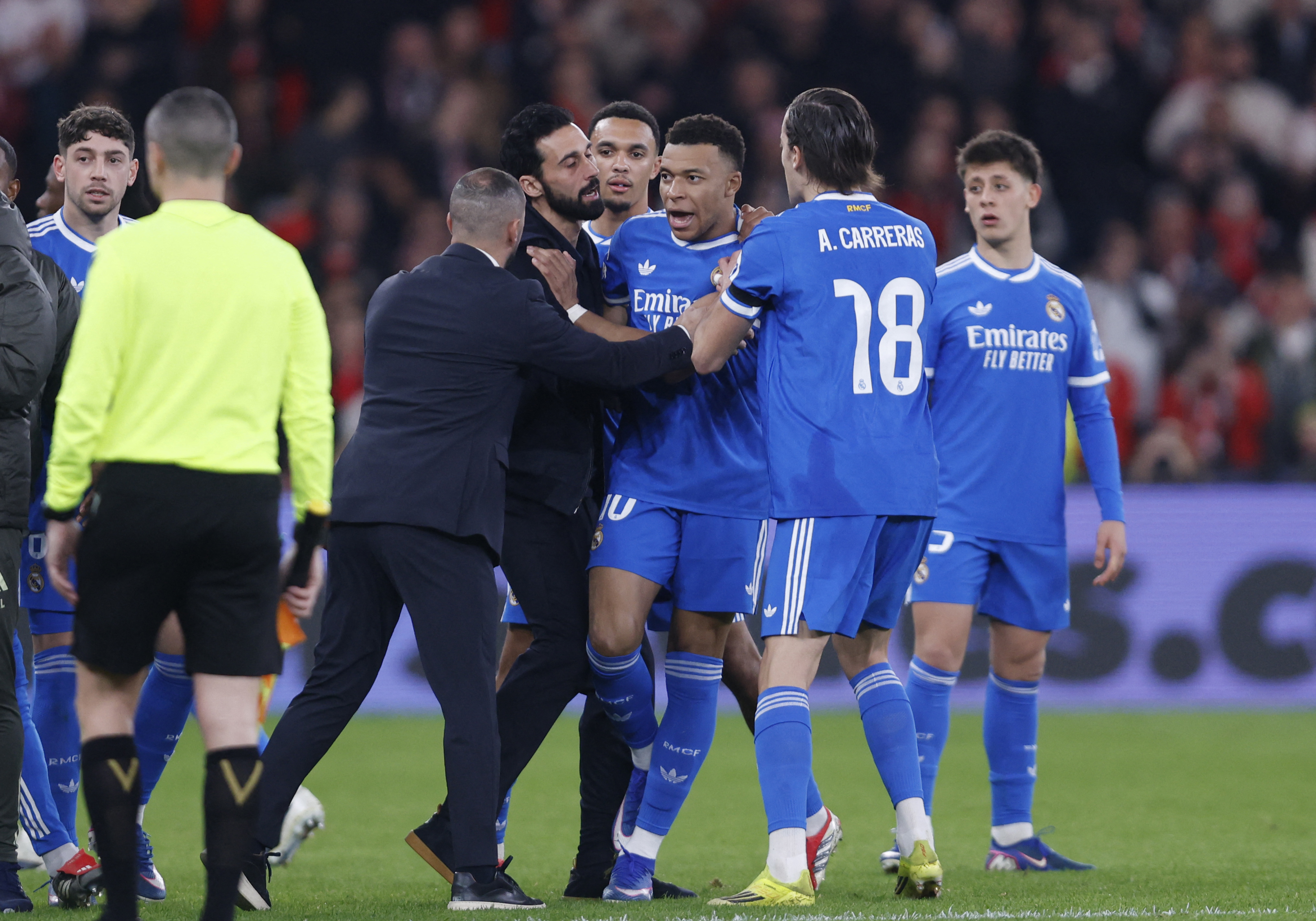 Real Madrid's French forward #10 Kylian Mbappe reacts after Real Madrid's Brazilian forward #07 Vinicius Junior (not seen) listened racists insults during the UEFA Champions League knockout round play-off first leg football match between SL Benfica and Re