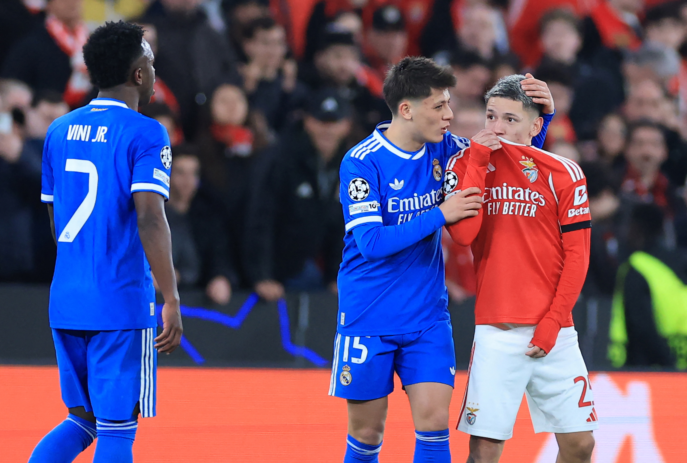 SL Benfica's Argentine forward #25 Gianluca Prestianni hides his mouth while arguing with Real Madrid's Brazilian forward #07 Vinicius Junior who complained about alleged racists insults during the UEFA Champions League knockout round play-off first leg f