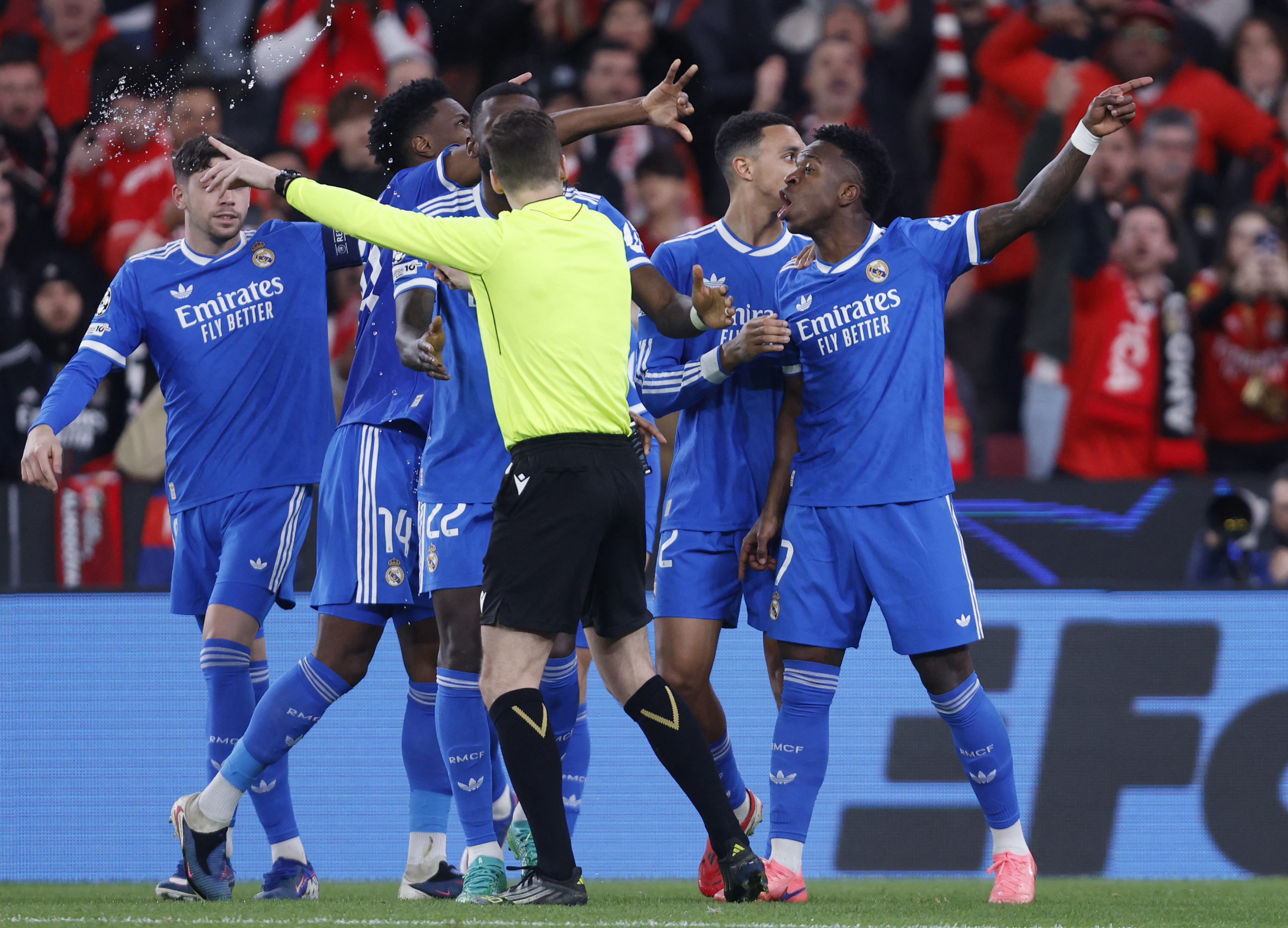 French referee Francois Letexier argues with Real Madrid's Brazilian forward #07 Vinicius Junior as he celebrates scoring his team's first goal during the UEFA Champions League knockout round play-off first leg football match between SL Benfica and Real M