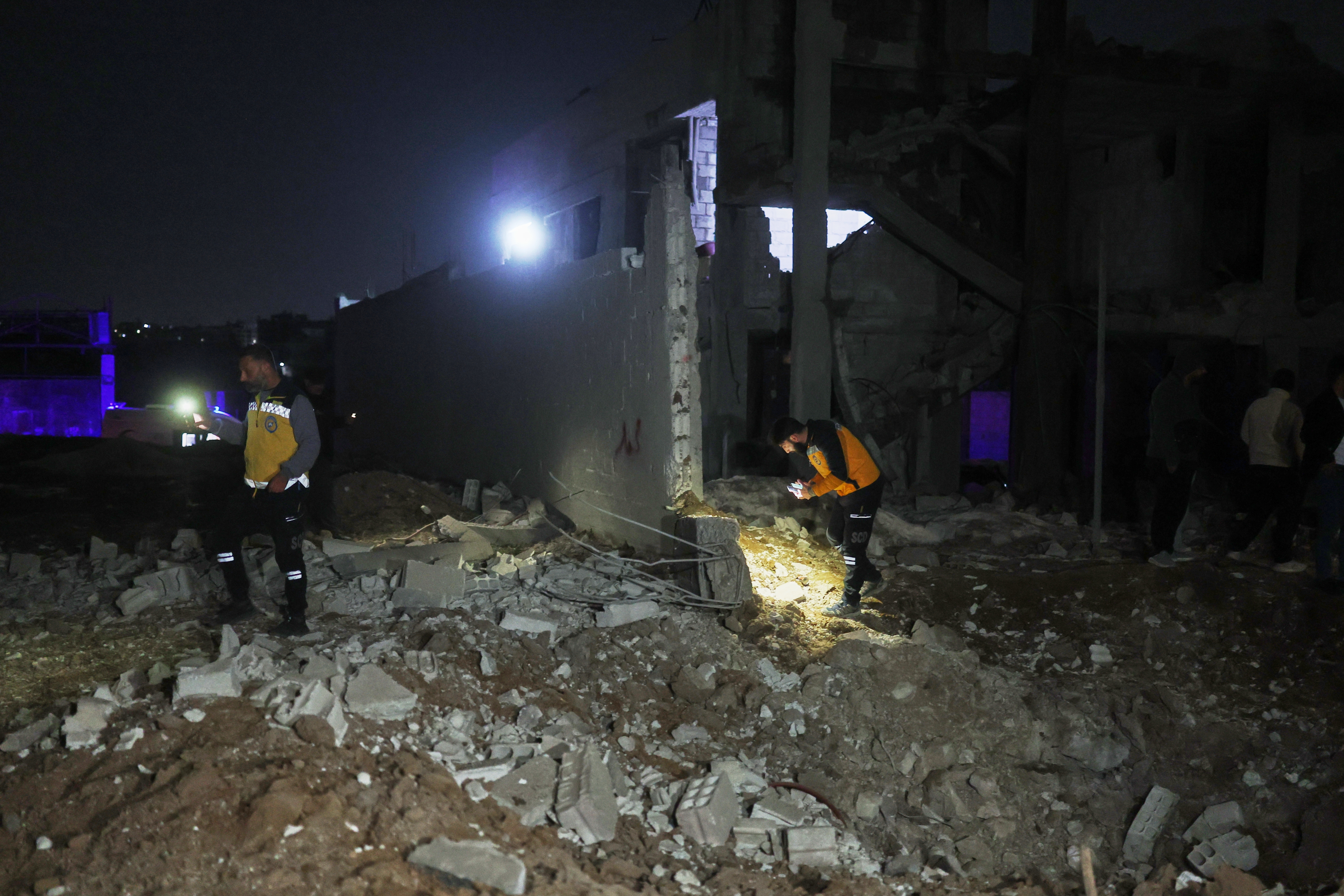 Members of the Syrian Civil Defense inspect a building after debris from an Iranian missile fell, injuring at least four people, including three children, according to Syria's state news agency SANA, in the town of Ain Terma, near Damascus, Syria, Sunday,