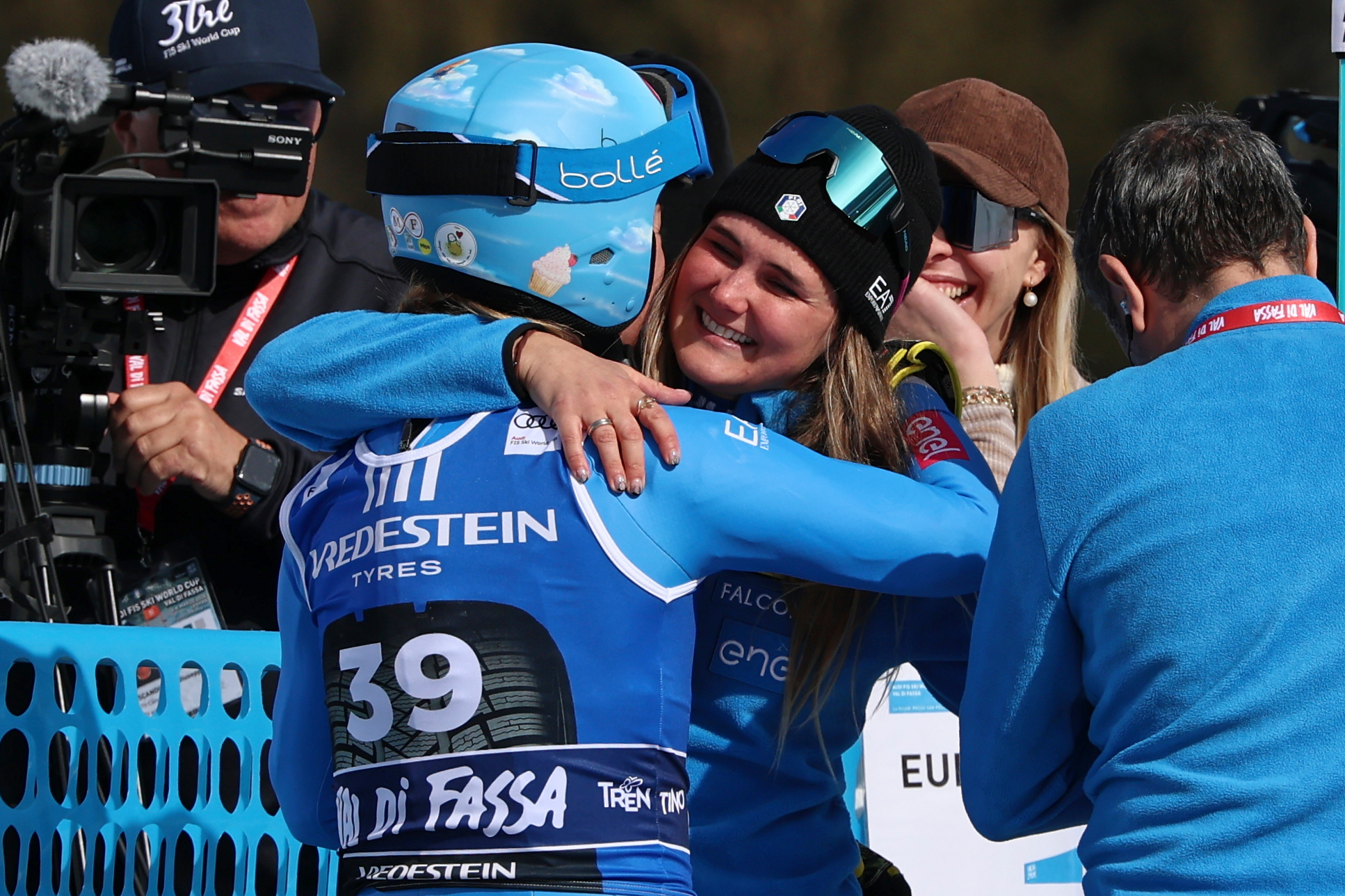Italy's Laura Pirovano, center, is hugged by Italy's Roberta Melesi at the finish area of an alpine ski, women's World Cup downhill, in Val di Fassa, Italy, Friday, March 6, 2026. (AP Photo/Luciano Bisi)