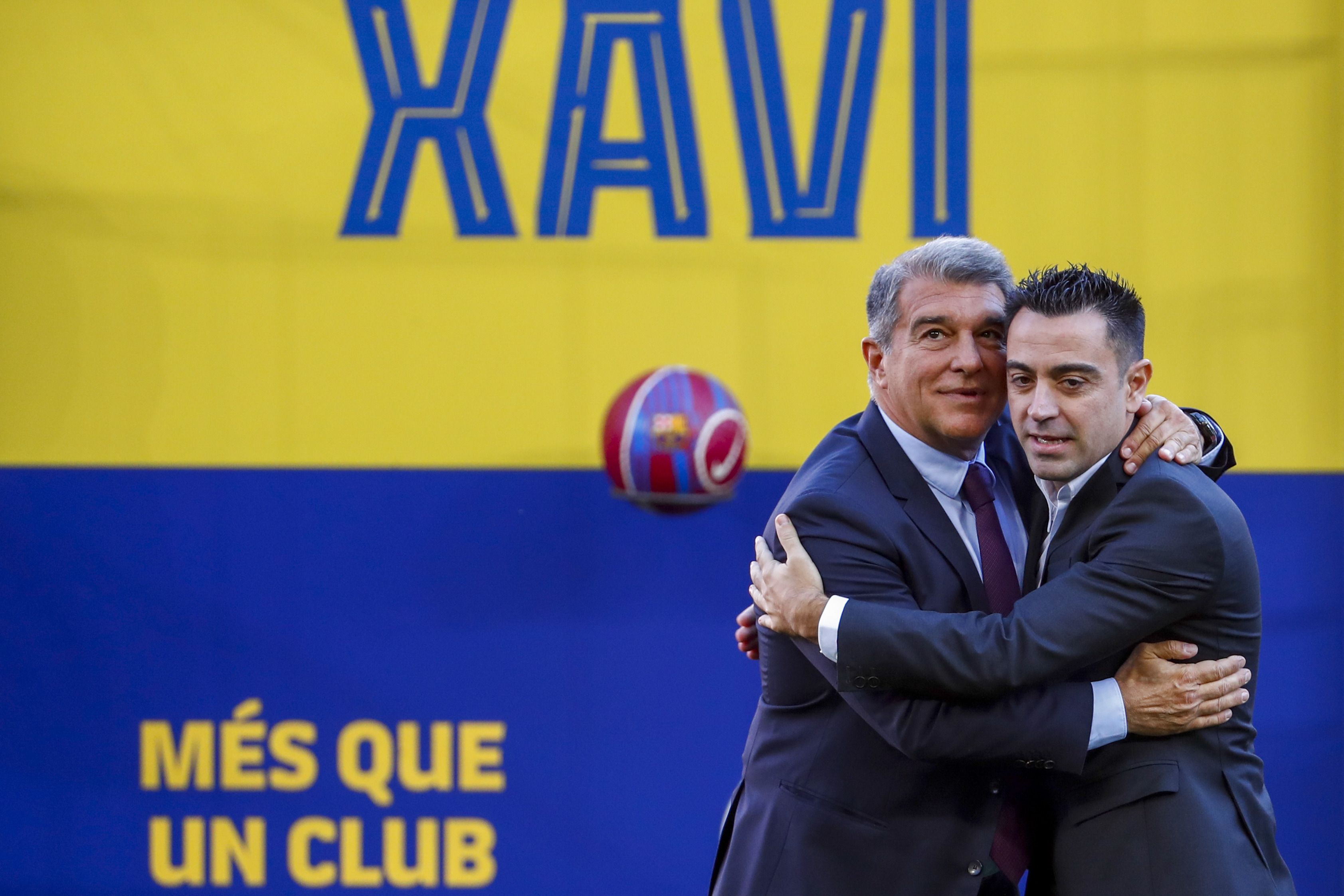 FC Barcelona's new coach Xavi Hernandez, right, embraces FC Barcelona president Joan Laporta during his official presentation at the Camp Nou stadium in Barcelona, Spain, Monday, Nov. 8, 2021. Xavi, who thrived in Barcelona’s midfield alongside Messi and