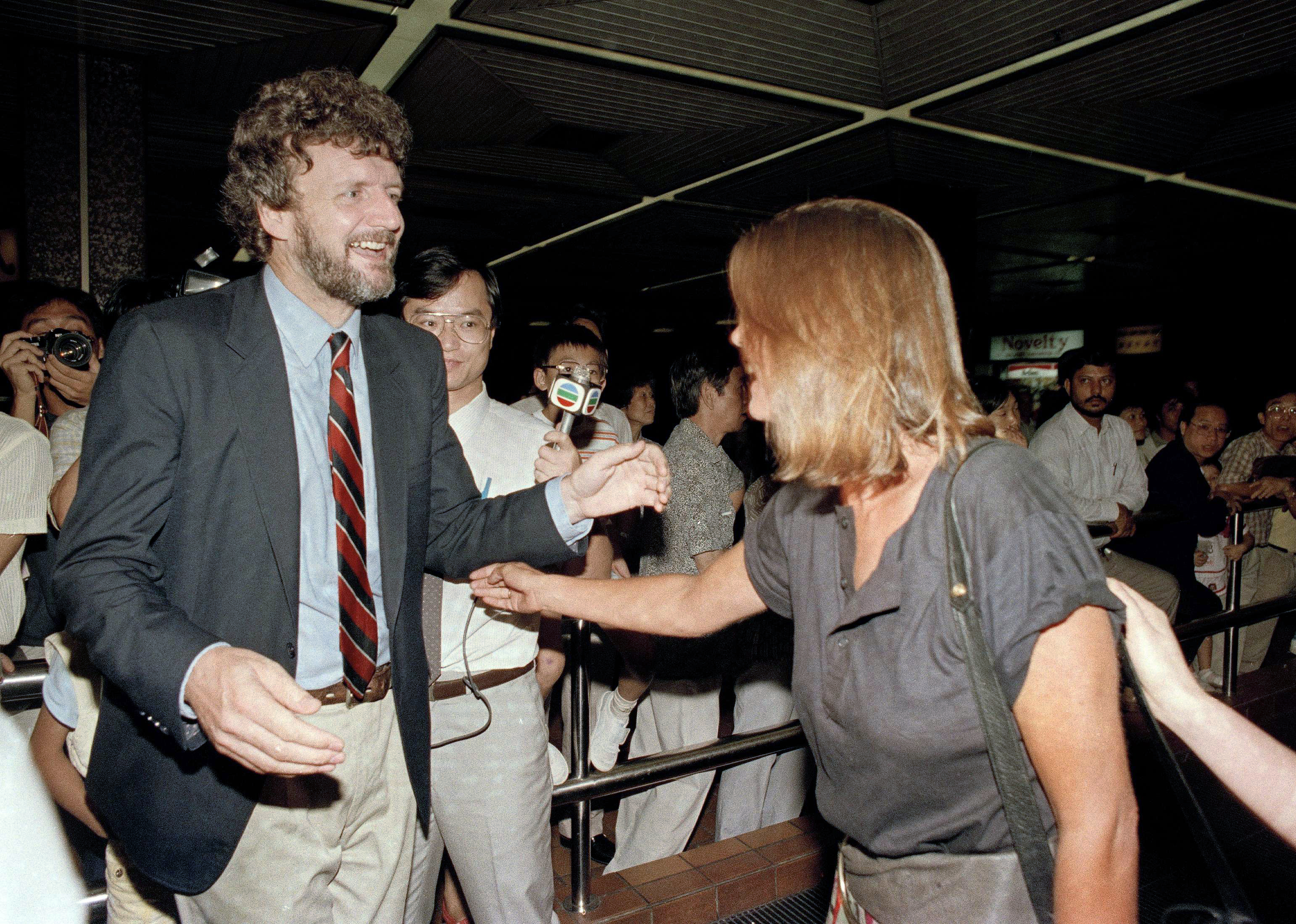 New York Times correspondent John Burns is reunited with his wife, Jane Scott-Long (AP Photo/Dick Fung)