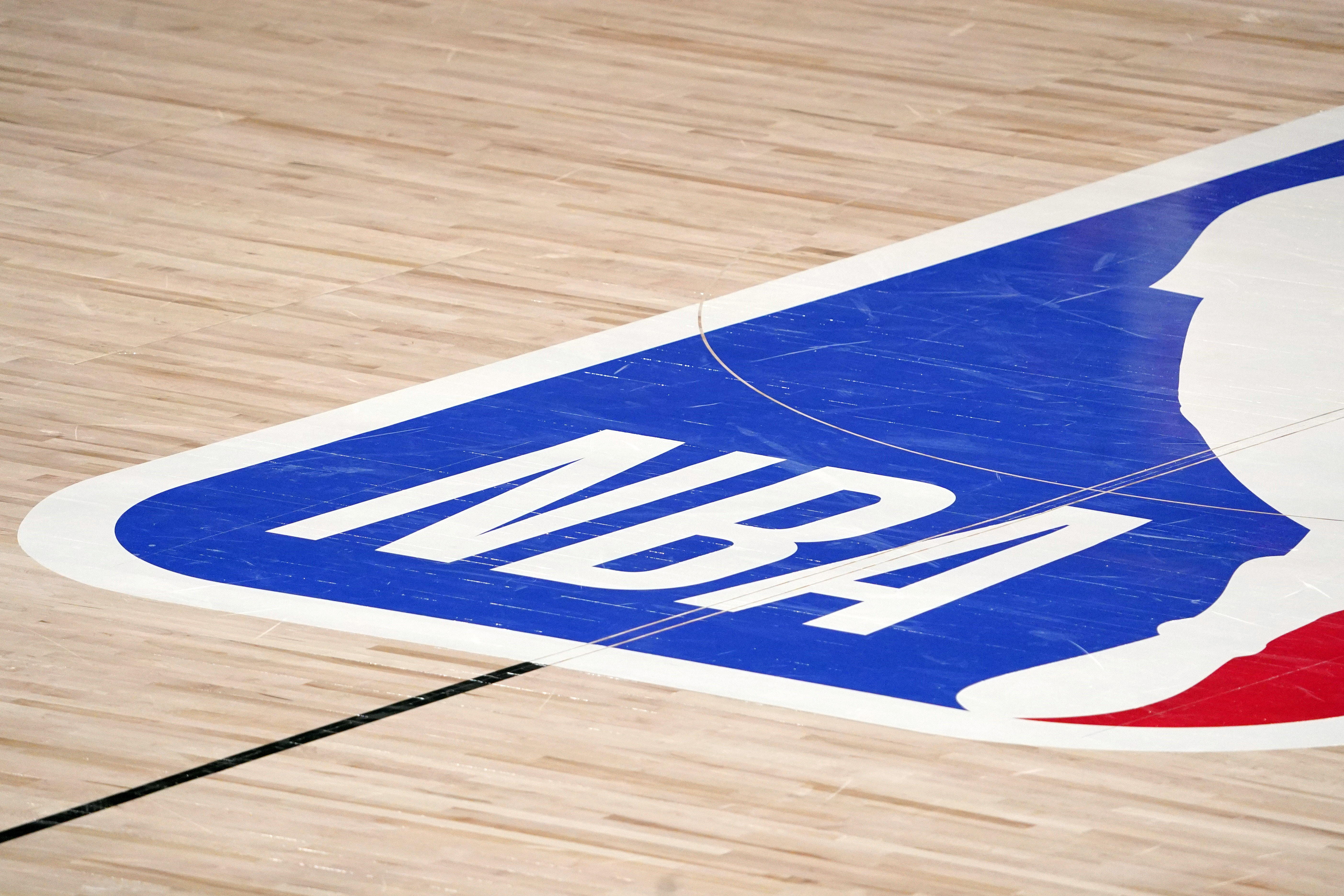 FILE -  The NBA logo at center court is shown during the second half of an NBA first-round playoff basketball game between the Houston Rockets and Oklahoma City Thunder in Lake Buena Vista, Fla., Wednesday, Sept. 2, 2020. The NBA has agreed to terms on it