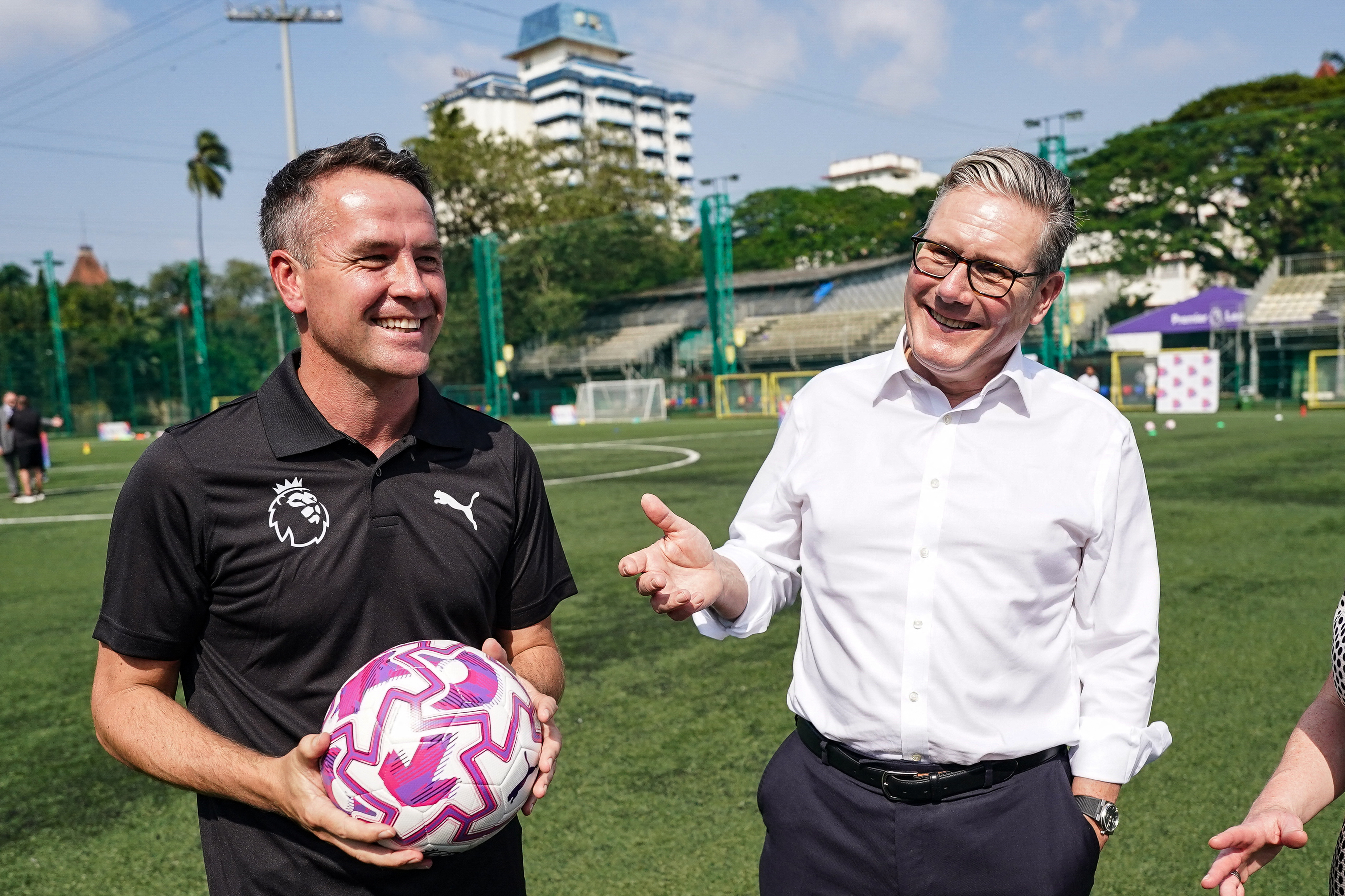 Britain's Prime Minister Keir Starmer (R) speaks with former English footballer