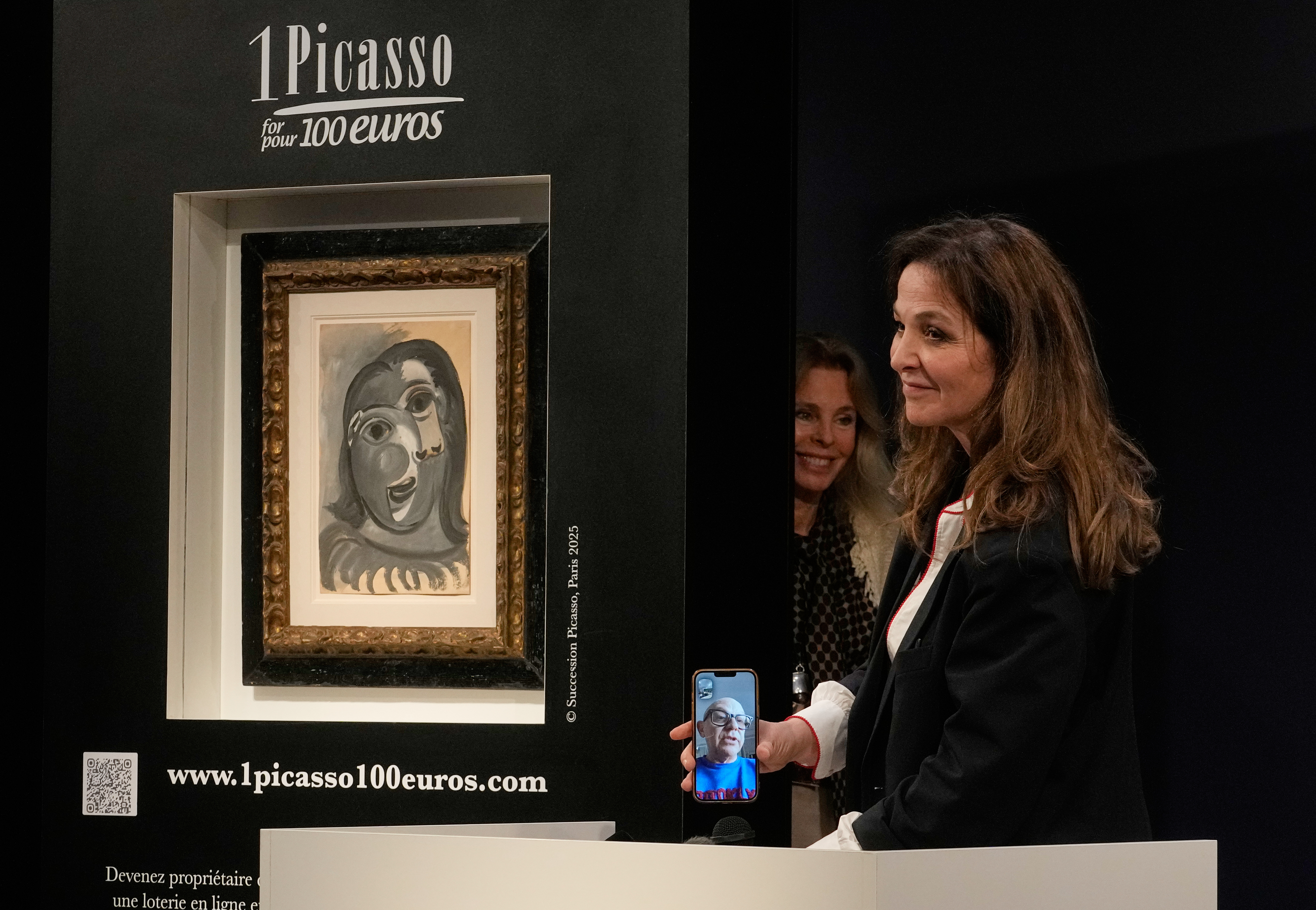 Peri Cochin, right, founder of "1 Picasso for 100 euros," speaks with winner