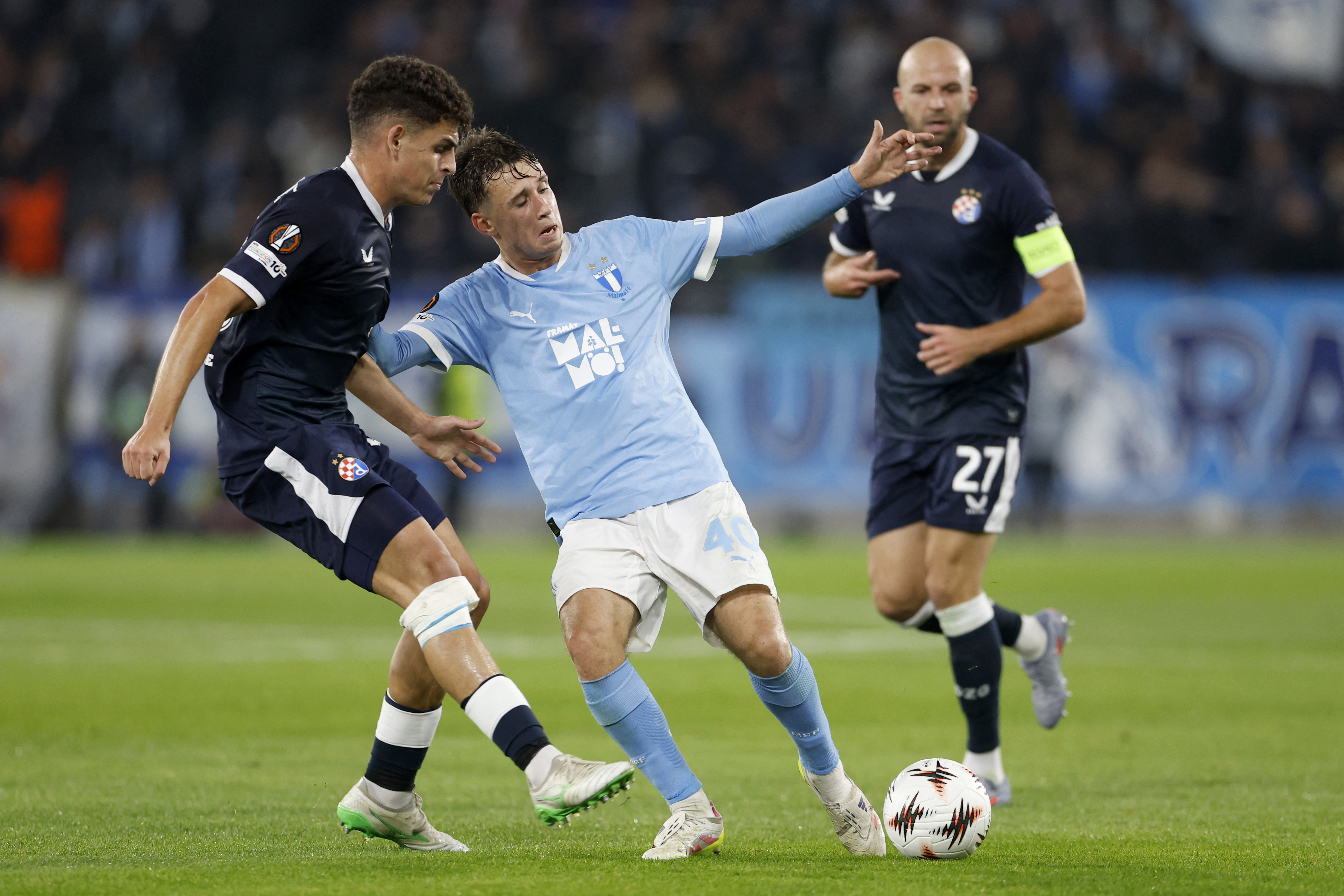 Dinamo Zagreb's Spanish defender #36 Sergi Dominguez (L) and Malmo FF's Swedish midfielder #40 Kenan Busuladzic (C) vie for the ball during the UEFA Europa League first round day 3 football match between Malmo FF and GNK Dinamo, in Malmo on October 23, 20