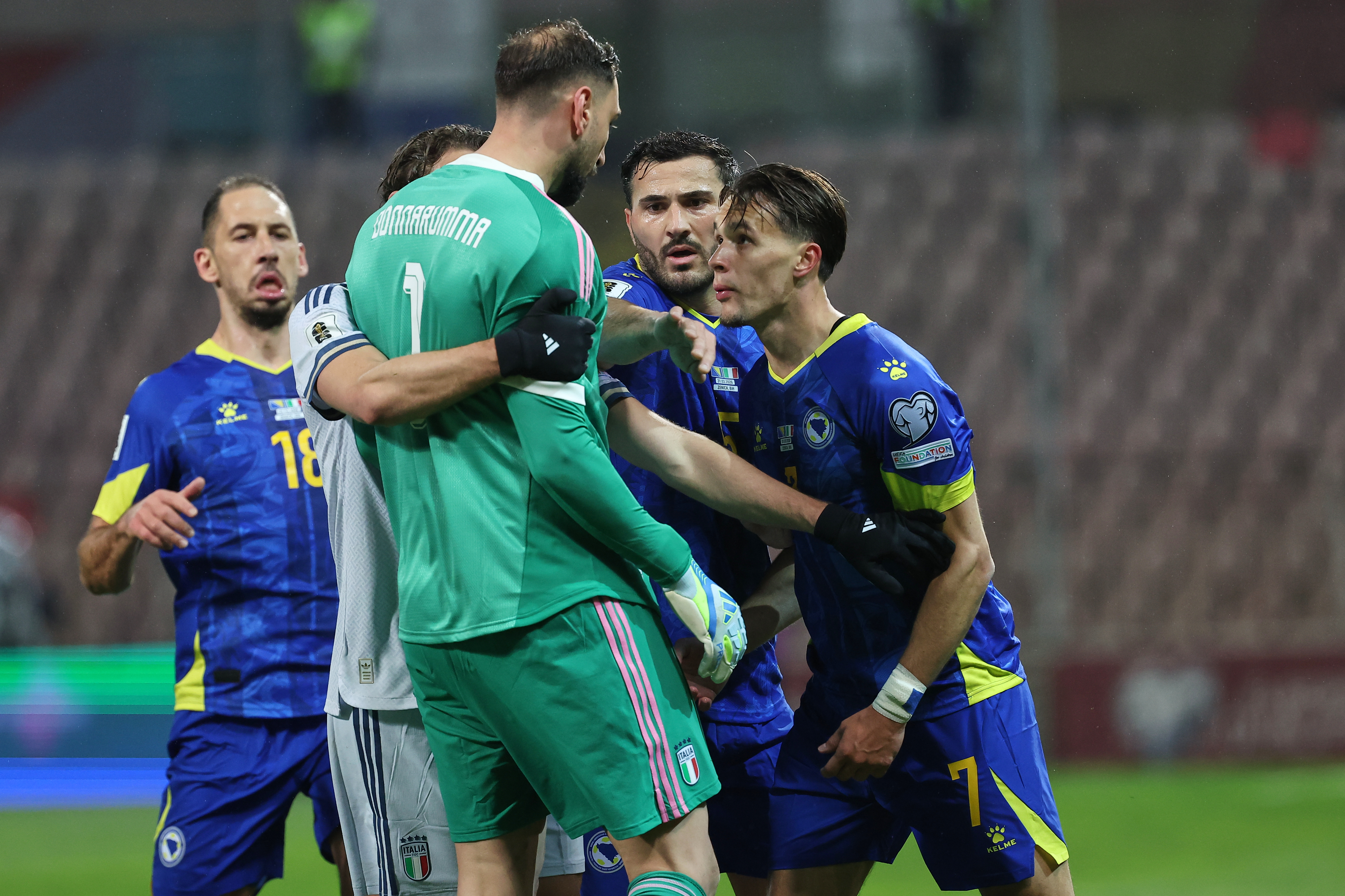 Italy goalkeeper Gianluigi Donnarumma and Bosnia's Amar Dedic, right, clash during the World Cup qualifying playoff final soccer match between Bosnia and Italy in Zenica, Bosnia, Tuesday, March 31, 2026. (AP Photo/Armin Durgut)
