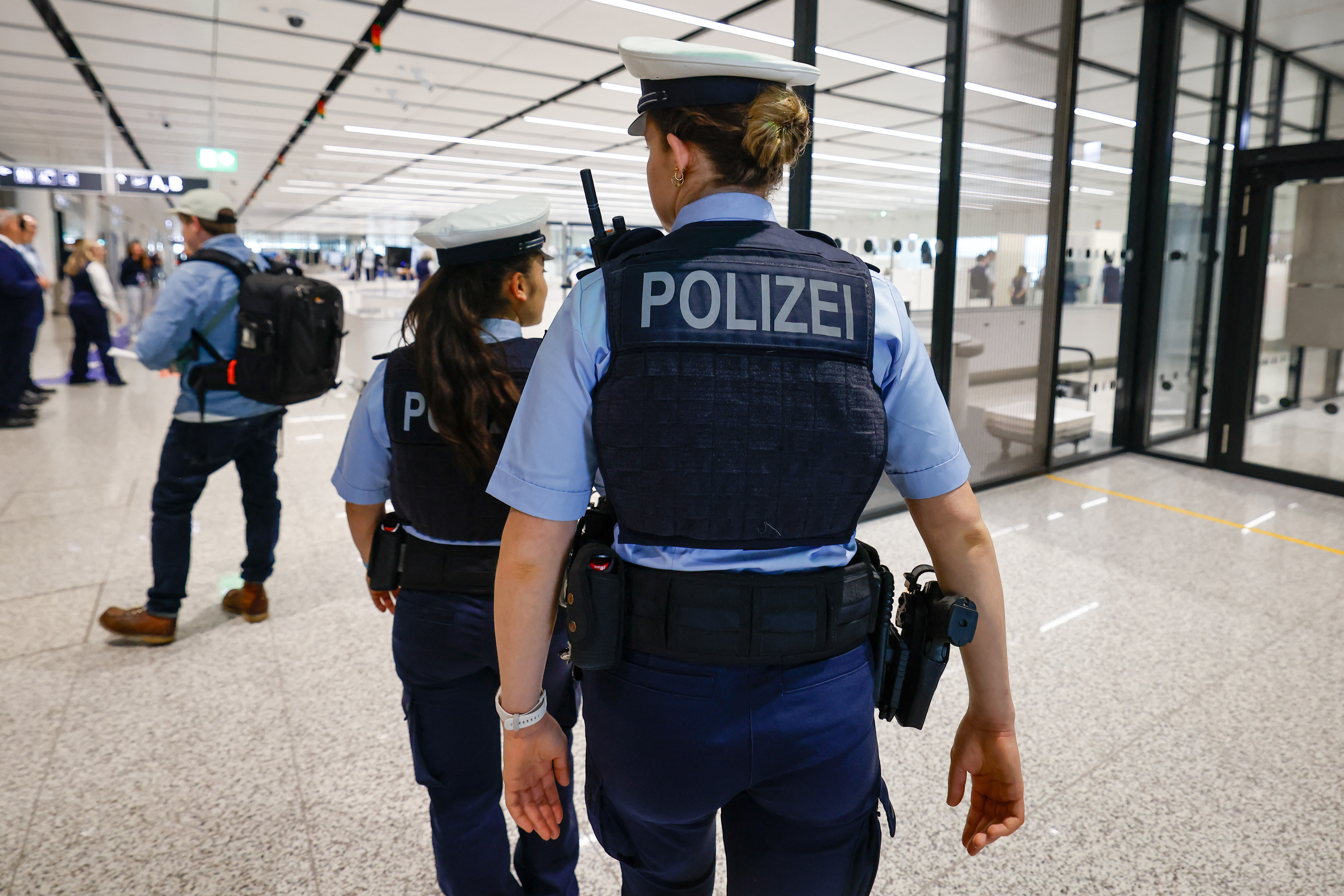 Two German police officers patrol at the security check area of the new Terminal 1 pier at Munich International Airport during the official opening in Munich on April 13, 2026. The Terminal 1 Pier provides additional capacity for up to six million passeng
