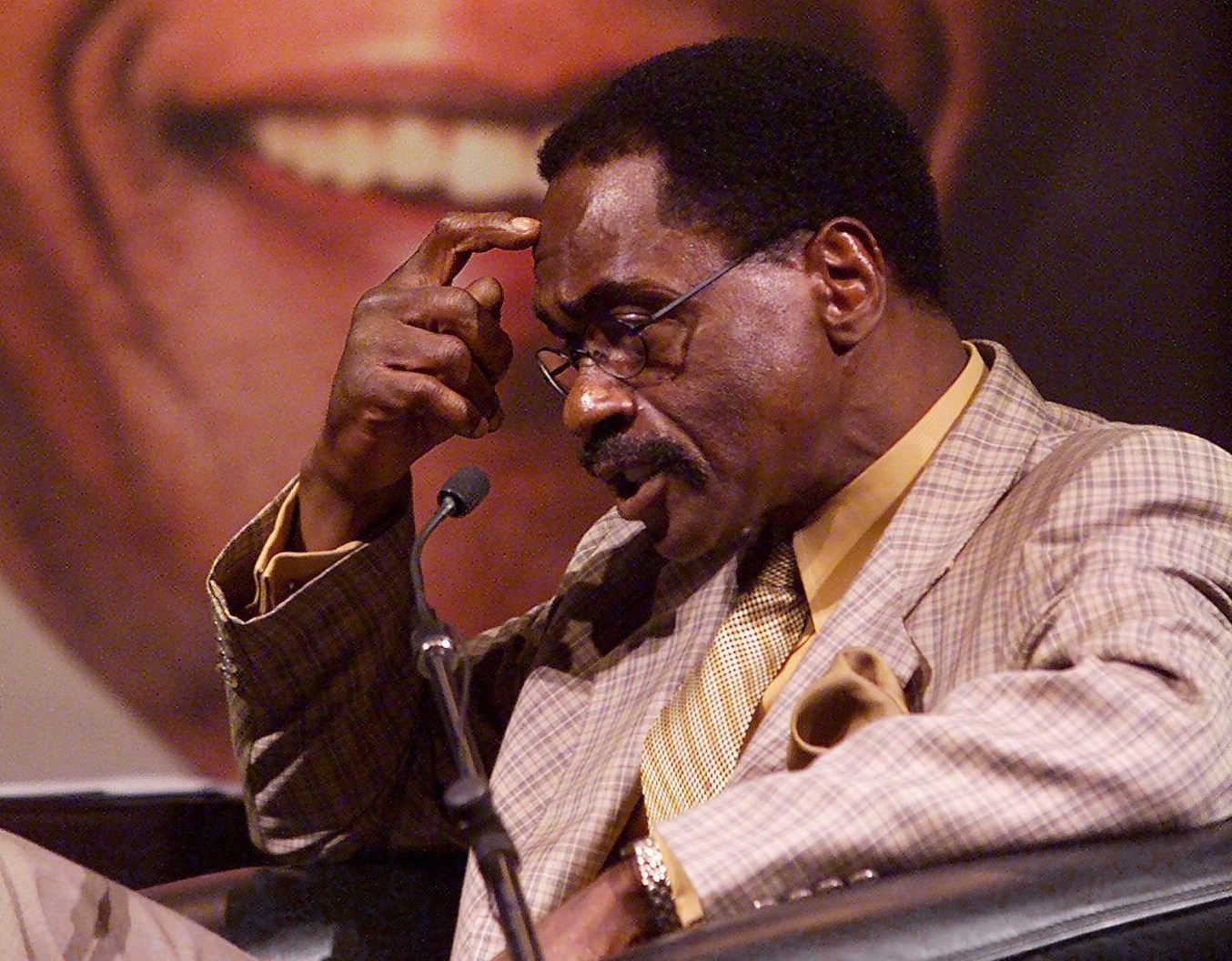 Former US boxer Rubin "Hurricane" Carter gathers his thoughts beneath a portrait of