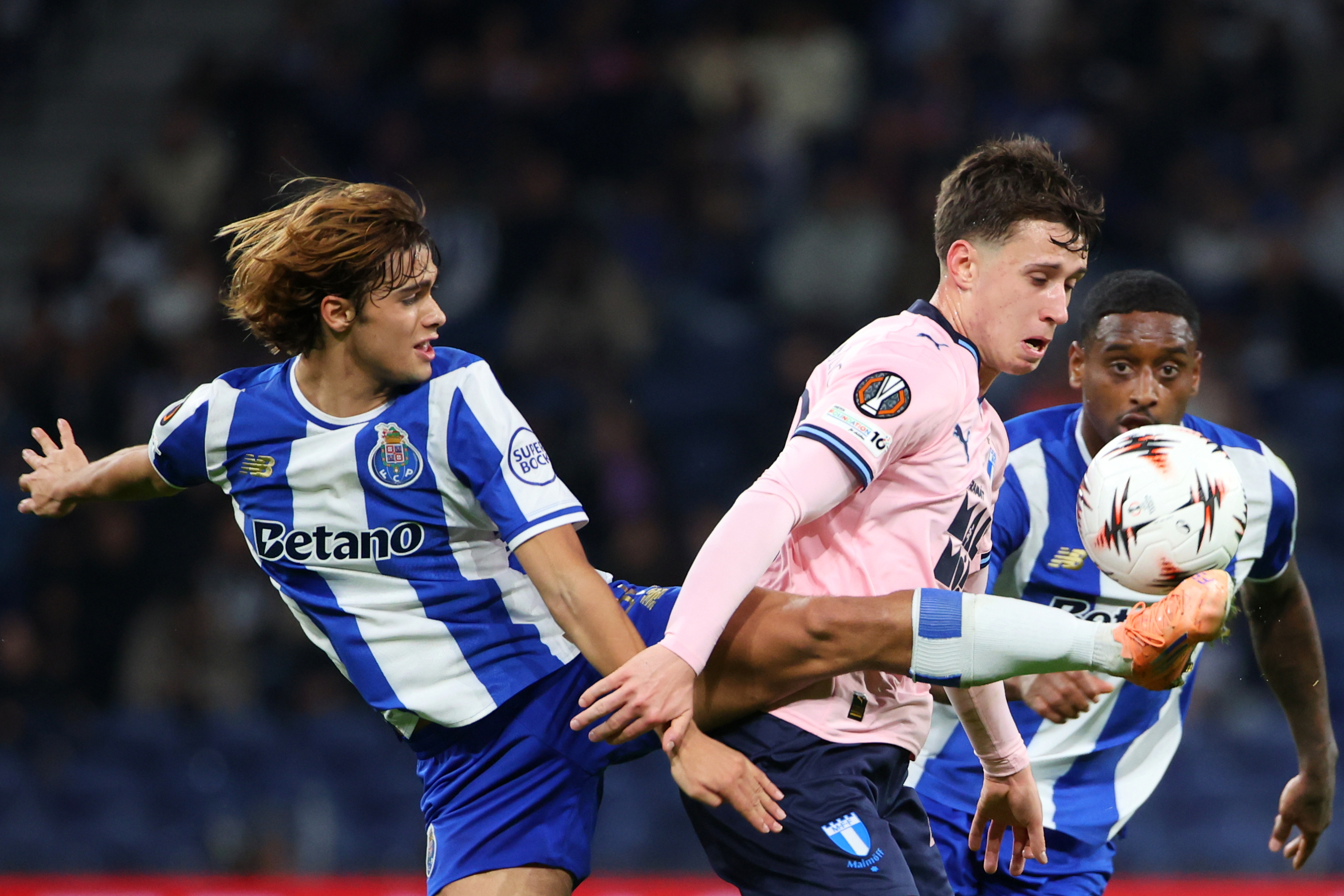 Porto's Rodrigo Mora, left, fights for the ball with Malmo's Kenan Busuladzic during the Europa League opening phase soccer match between FC Porto and Malmo in Porto, Portugal, Thursday, Dec. 11, 2025. (AP Photo/Luis Vieira)