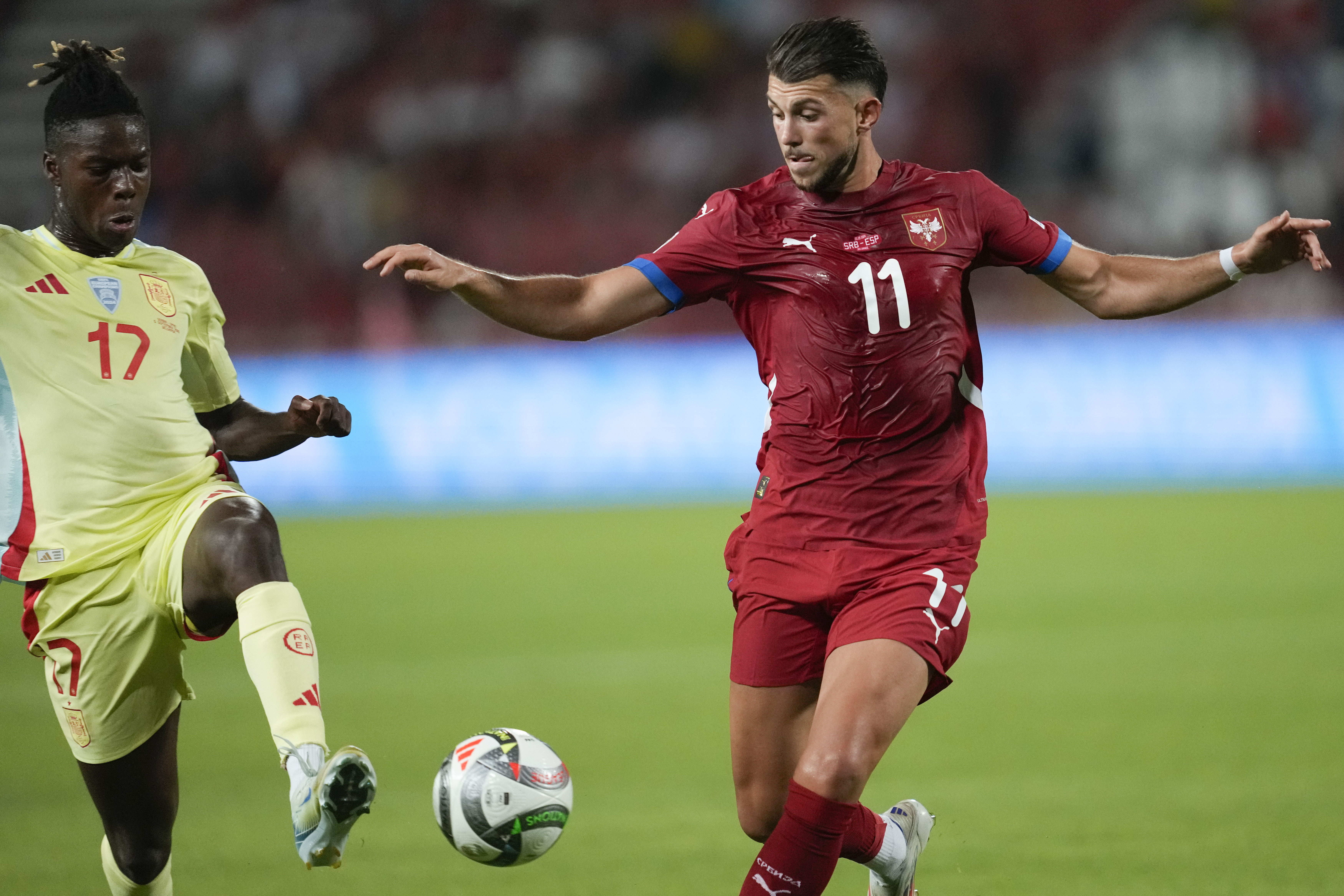 Spain's Nico Williams, left, challenges for the ball with Serbia's Lazar Samardzic during the UEFA Nations League soccer match between Serbia and Spain at the Rajko Mitic Stadium, in Belgrade, Serbia, Thursday, Sept. 5, 2024. (AP Photo/Darko Vojinovic)