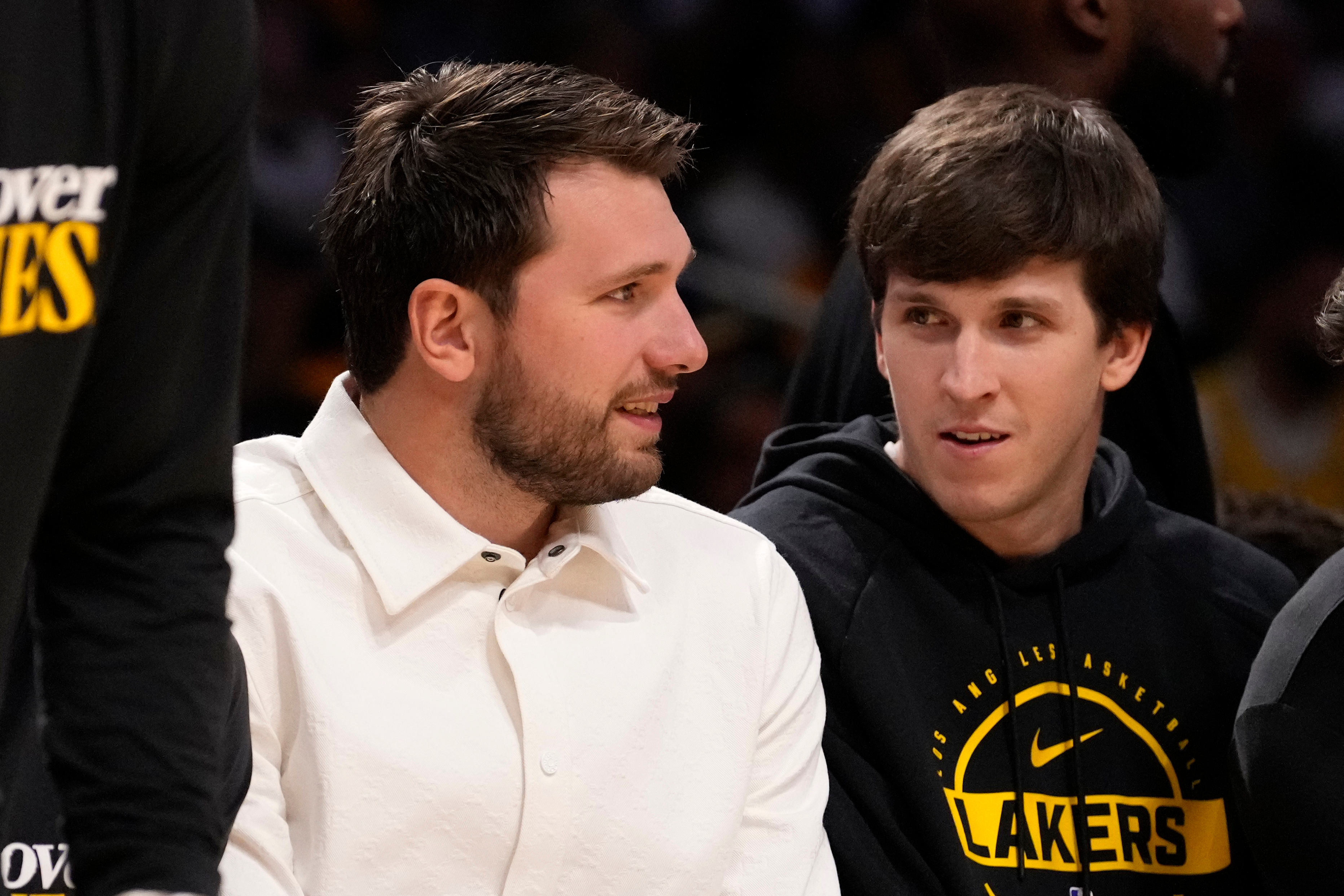 Los Angeles Lakers' Luka Doncic, left, and Austin Reaves chat as they sit on the bench during the second half in Game 1 of a first-round NBA playoffs basketball series against the Houston Rockets, Saturday, April 18, 2026, in Los Angeles. (AP Photo/Mark J