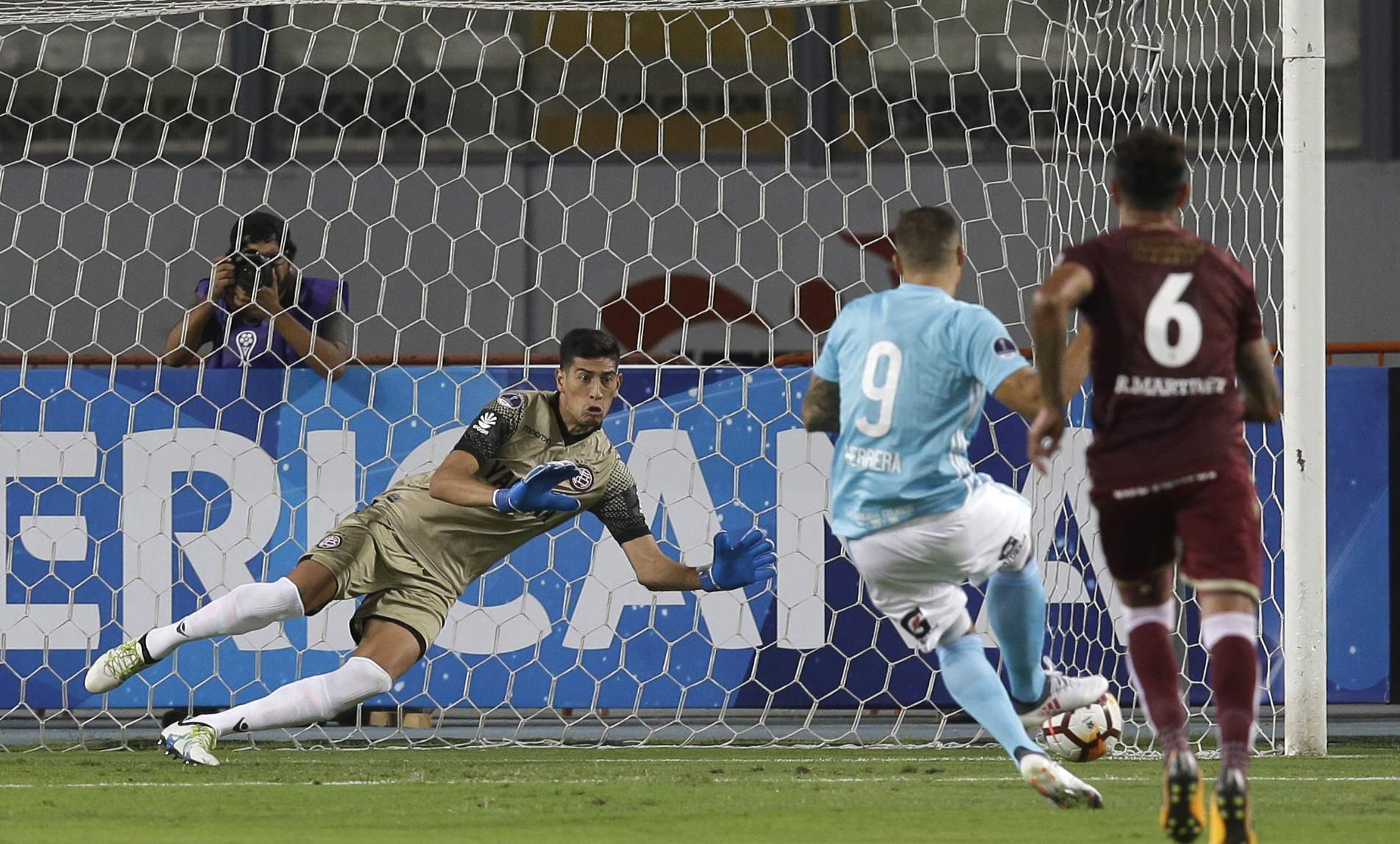 Emanuel Herrera (9) of Peru's Sporting Cristal scores against Esteban Andrade goalkeeper of Argentina's Lanus, during a Copa Sudamericana soccer match in Lima, Peru, Wednesday, March 7, 2018. (AP Photo/Martin Mejia)