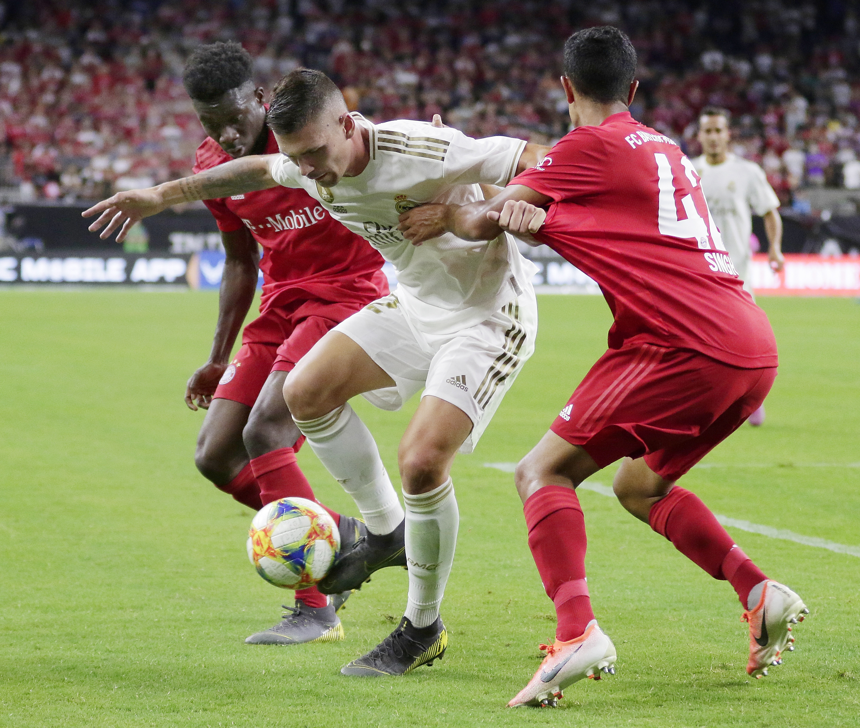 Real Madrid defender Adrian De La Fuente, middle, works to get the ball out from between FC Bayern's David Alaba, left, and Sapreet Singh, right, during the second half of an International Champions Cup soccer match Saturday, July 20, 2019, in Houston. (A