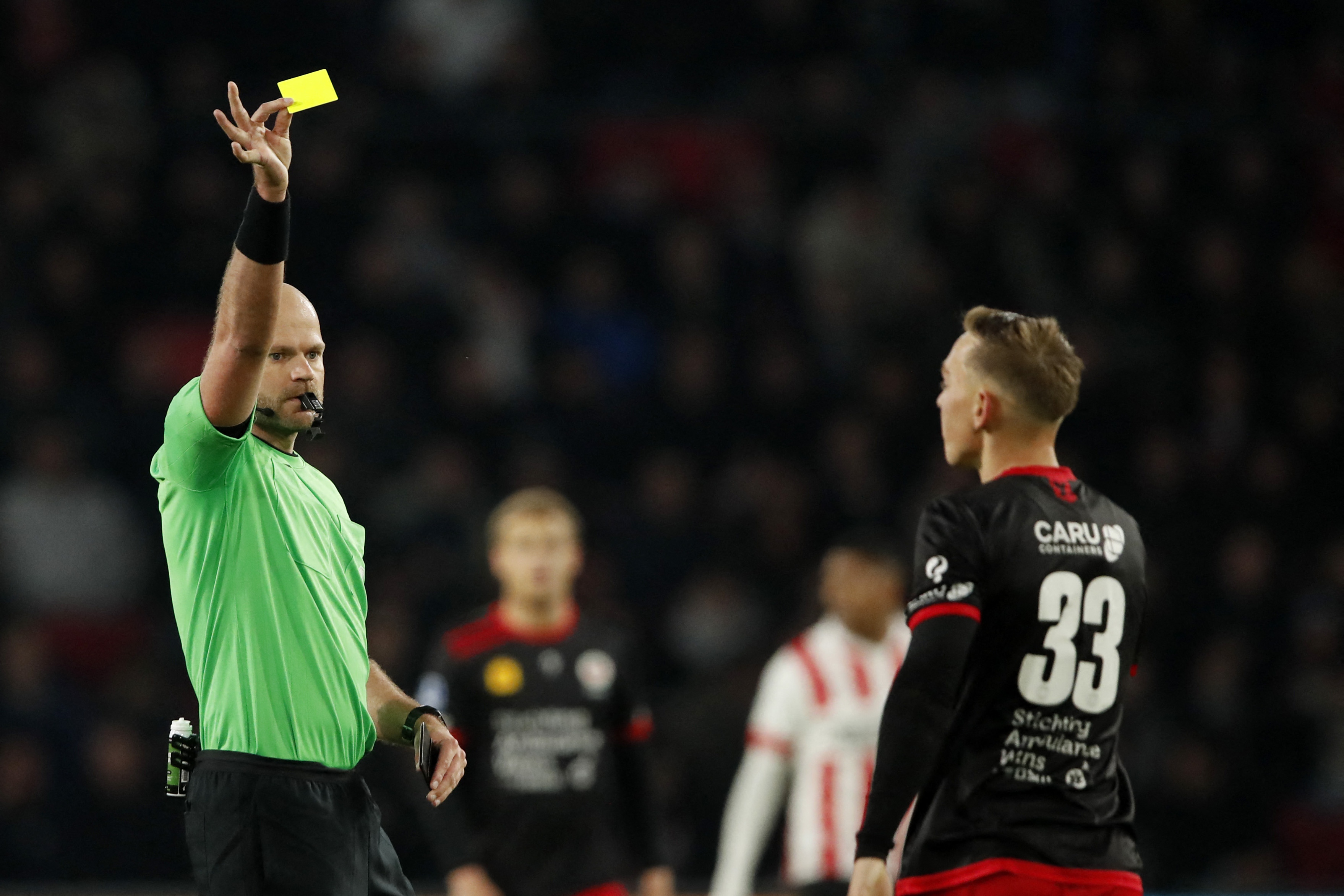 Referee Rob Dieperink (L) gives the yellow card to Excelsior's Dutch midfielder  Julian
