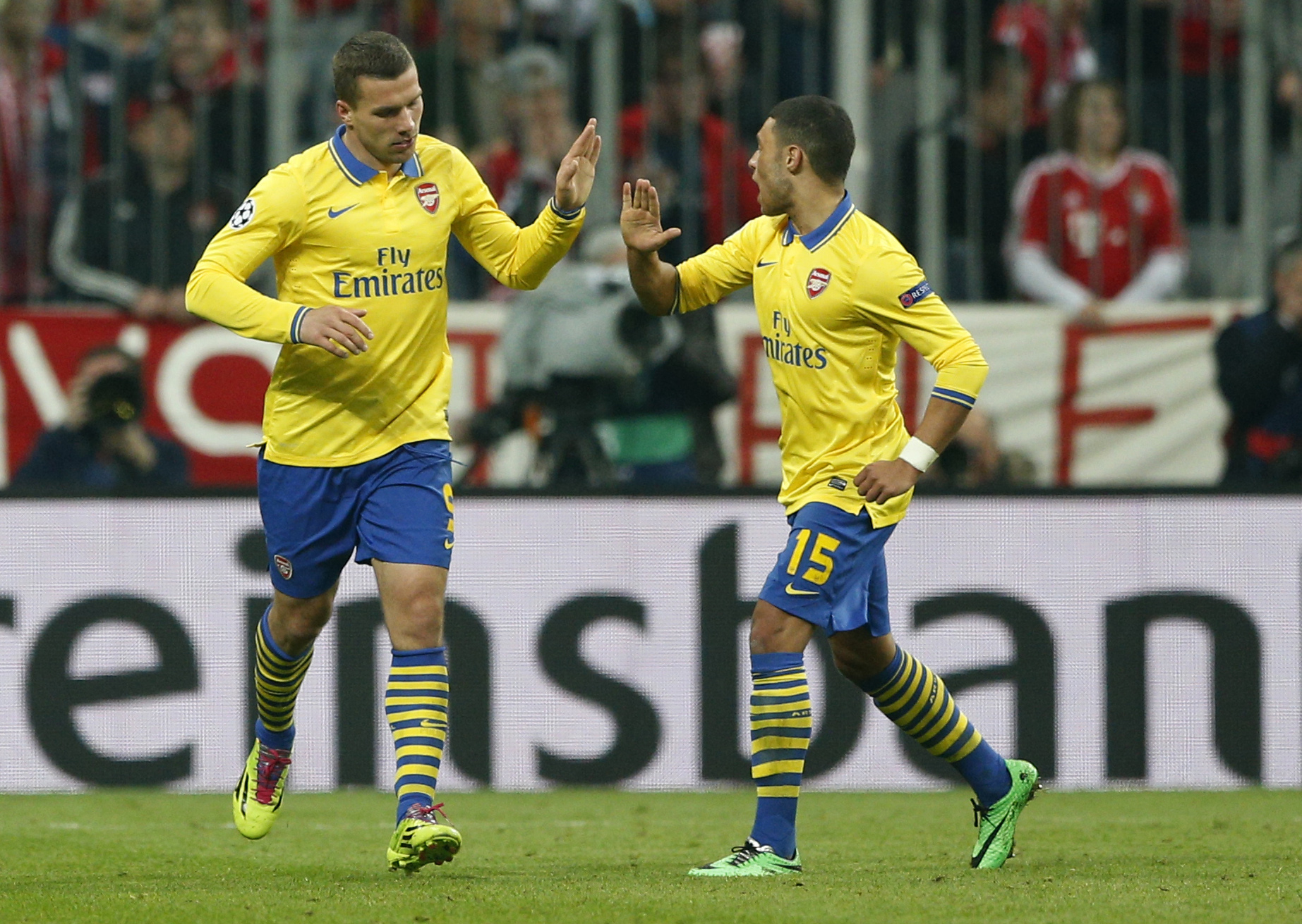 Arsenal's Lukas Podolski, left, is congratulated by Alex Oxlade-Chamberlain after scoring their side's first goal during the Champions League round of 16 second leg soccer match between FC Bayern Munich and FC Arsenal in Munich , Germany, Wednesday,