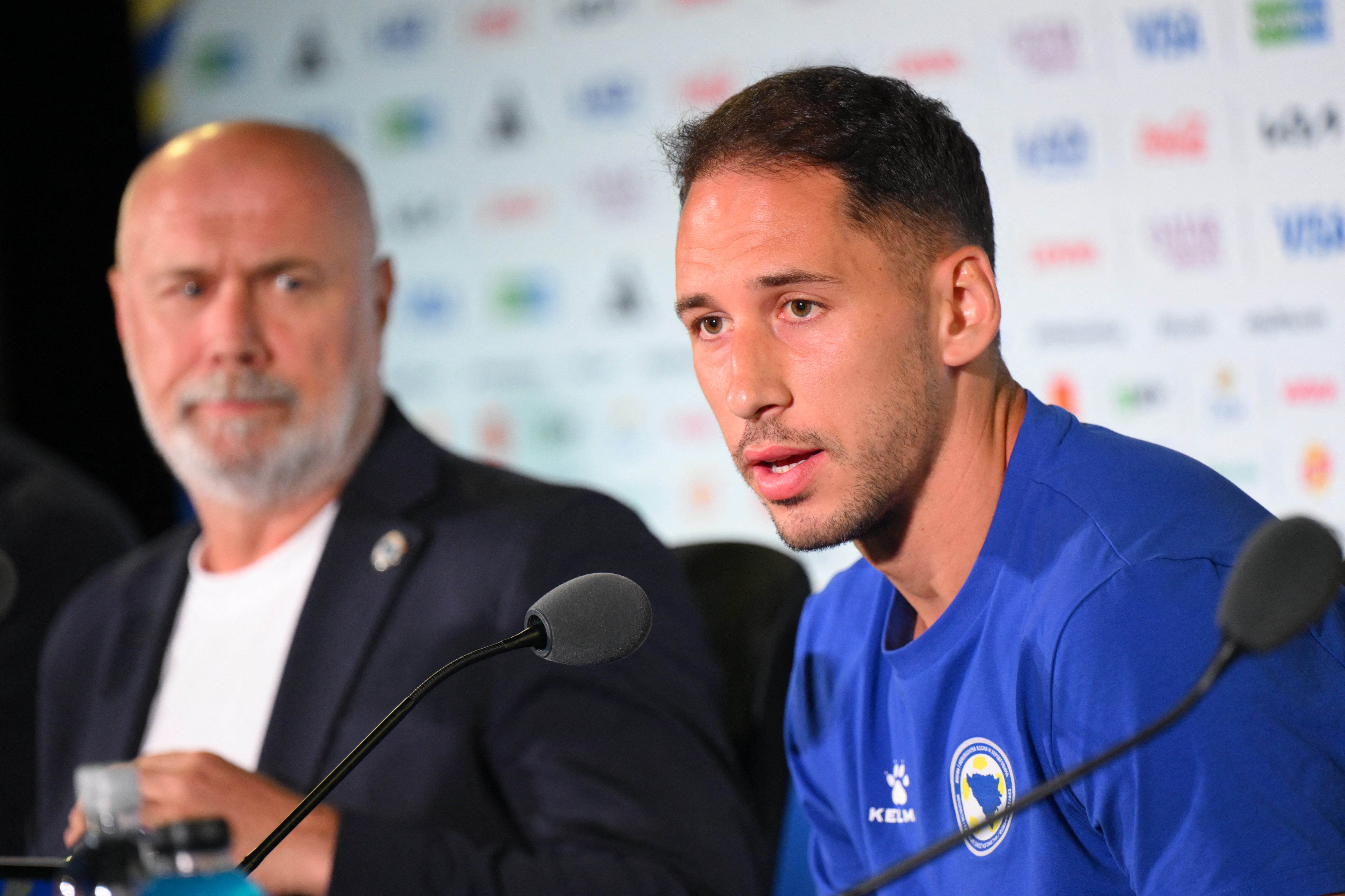 Bosnia-Herzegovina's Nikola Katic (R) gives a press conference next to head coach Sergej Barbarez (L) in Los Angeles, California on June 17, 2026, on the eve of the 2026 World Cup football match between Switzerland and Bosnia and Herzegovina.  (Photo by P