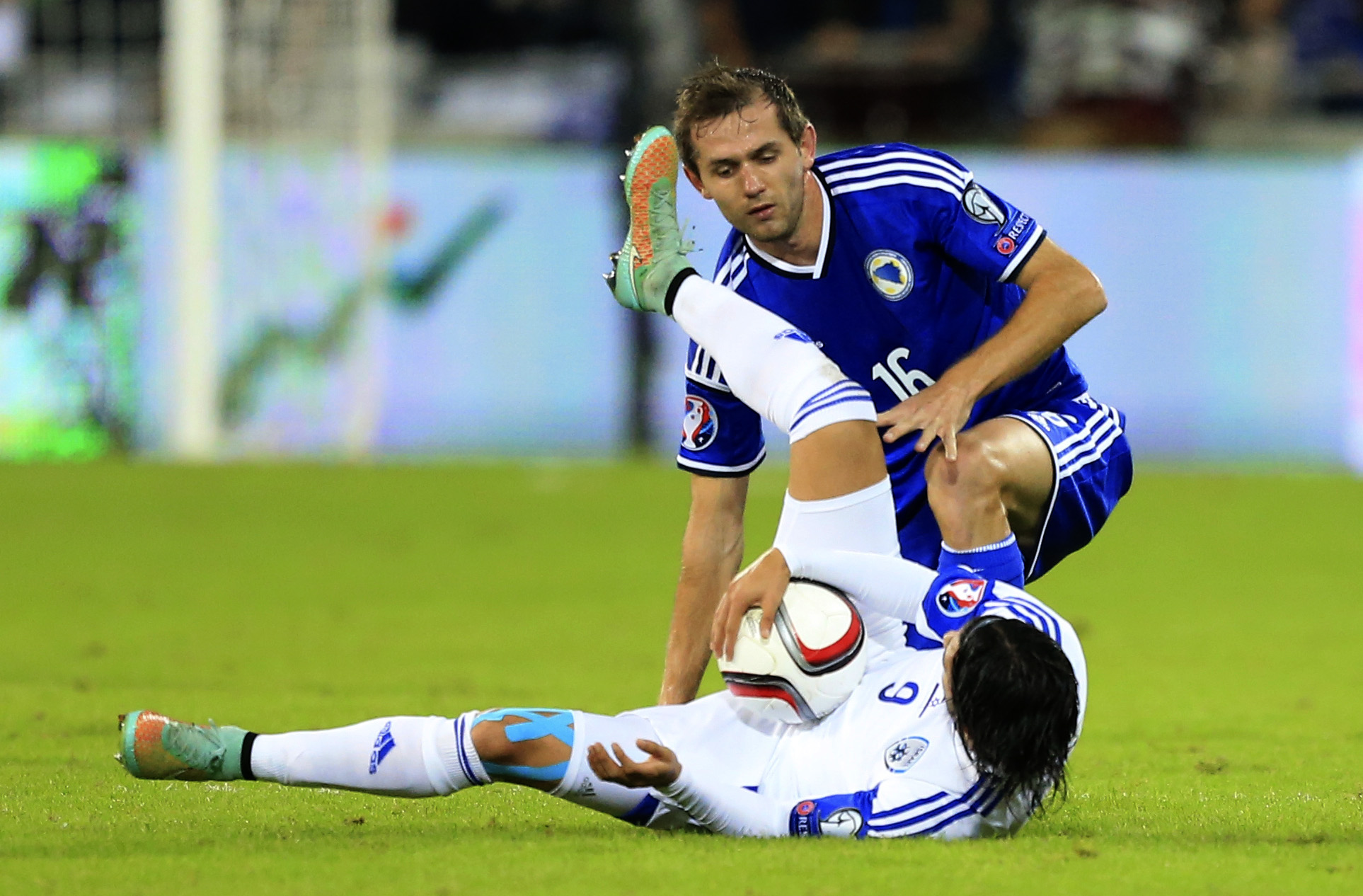 Israel’s Lior Rafaelov, front, and Bosnia’s Senad Lulic during their Euro 2016 soccer qualifying group B match in Haifa, Israel, Sunday, Nov. 16, 2014. (AP Photo/Ariel Schalit)