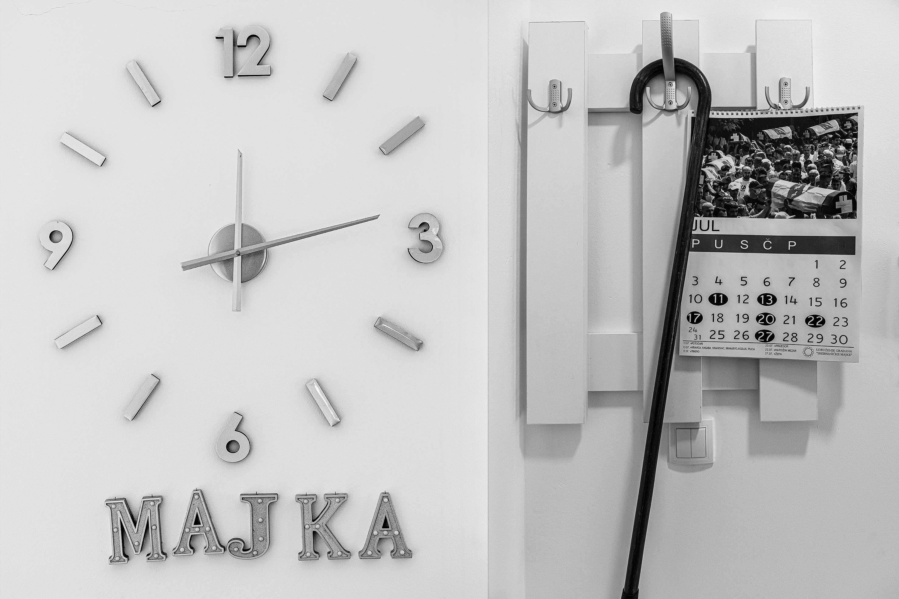 Fotografija iz ciklusa "Potočarske sjene" Velije Hasanbegovića prikazuje zid u kući jedne od majki u Potočarima: veliki sat sa natpisom "MAJKA", štap obješen na vješalici i kalendar otvoren na julu sa fotografijom kolektivne dženaze.