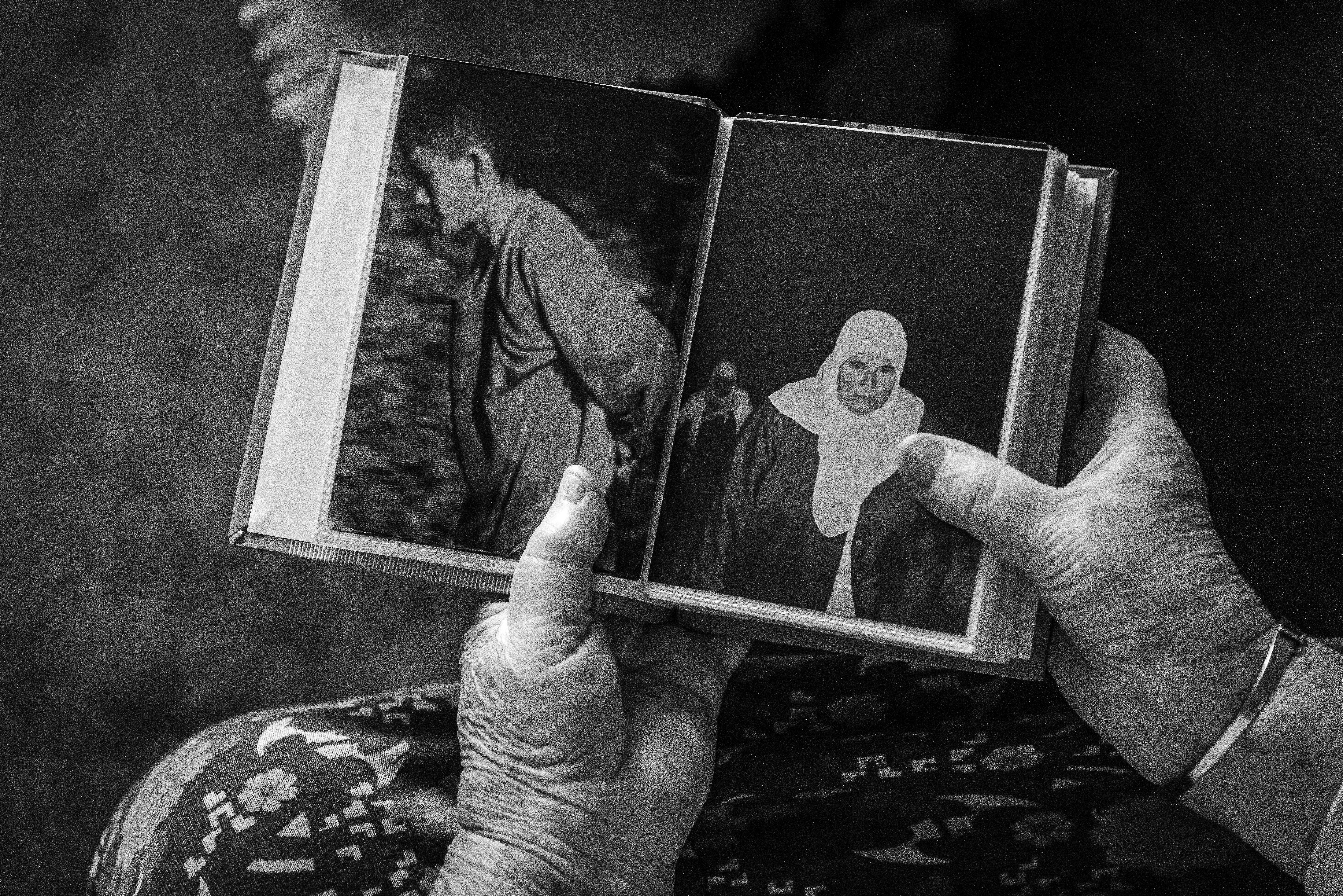 Fotografija iz ciklusa "Potočarske sjene" Velije Hasanbegovića prikazuje ruke starije žene koja drži album sa fotografijama. Na otvorenim stranicama nalaze se dvije crno-bijele fotografije: mladića u pokretu i žene sa maramom na glavi.
