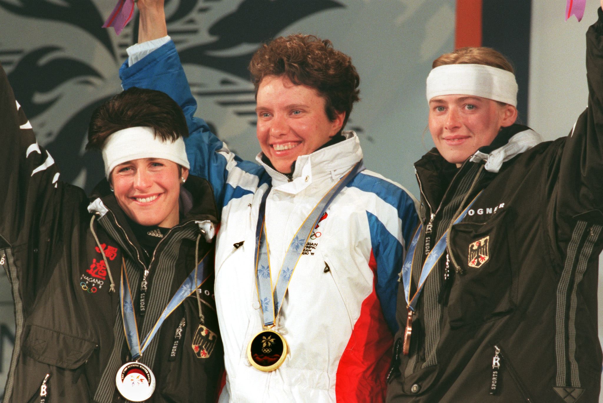 Winners of the women's Olympic 7.5km biathlon sprint wave from the stage after