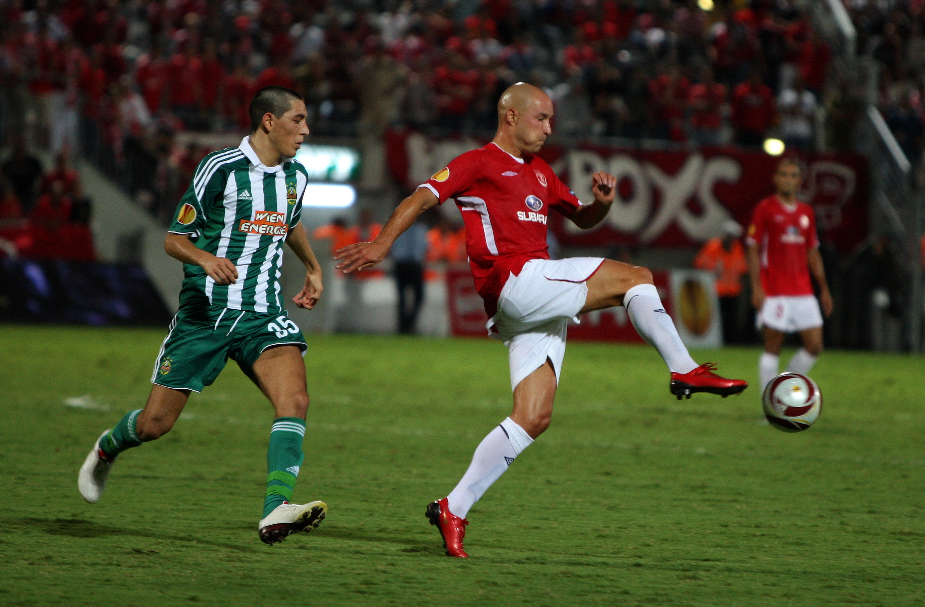 Rapid Vienna's midfielder Yassin Pehlivan (L) competes with Hapoel Tel Aviv's forward