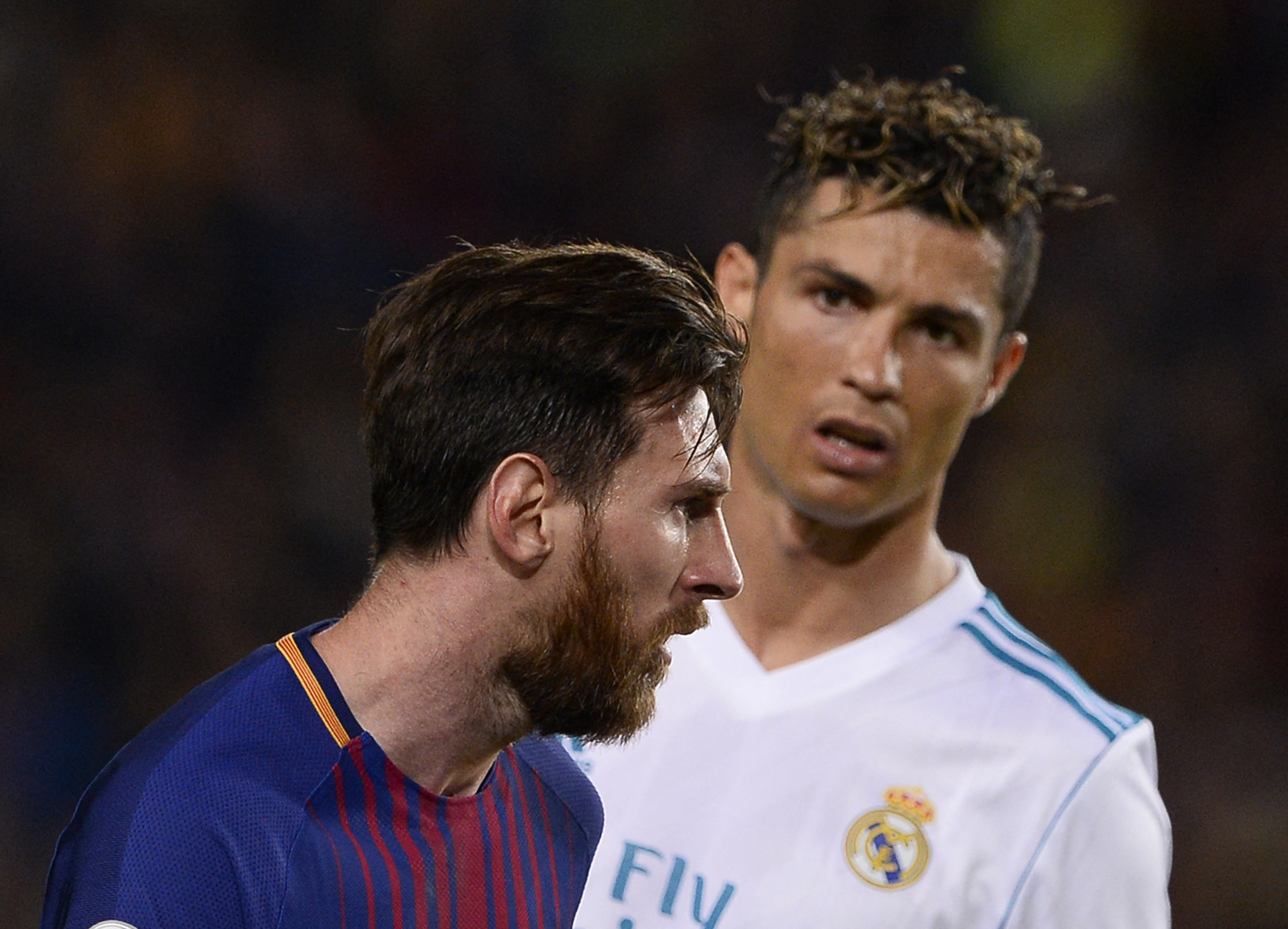 Real Madrid's Portuguese forward Cristiano Ronaldo (R) looks at Barcelona's Argentinian forward Lionel Messi during the Spanish league football match between FC Barcelona and Real Madrid CF at the Camp Nou stadium in Barcelona on May 6, 2018. (Photo by Jo