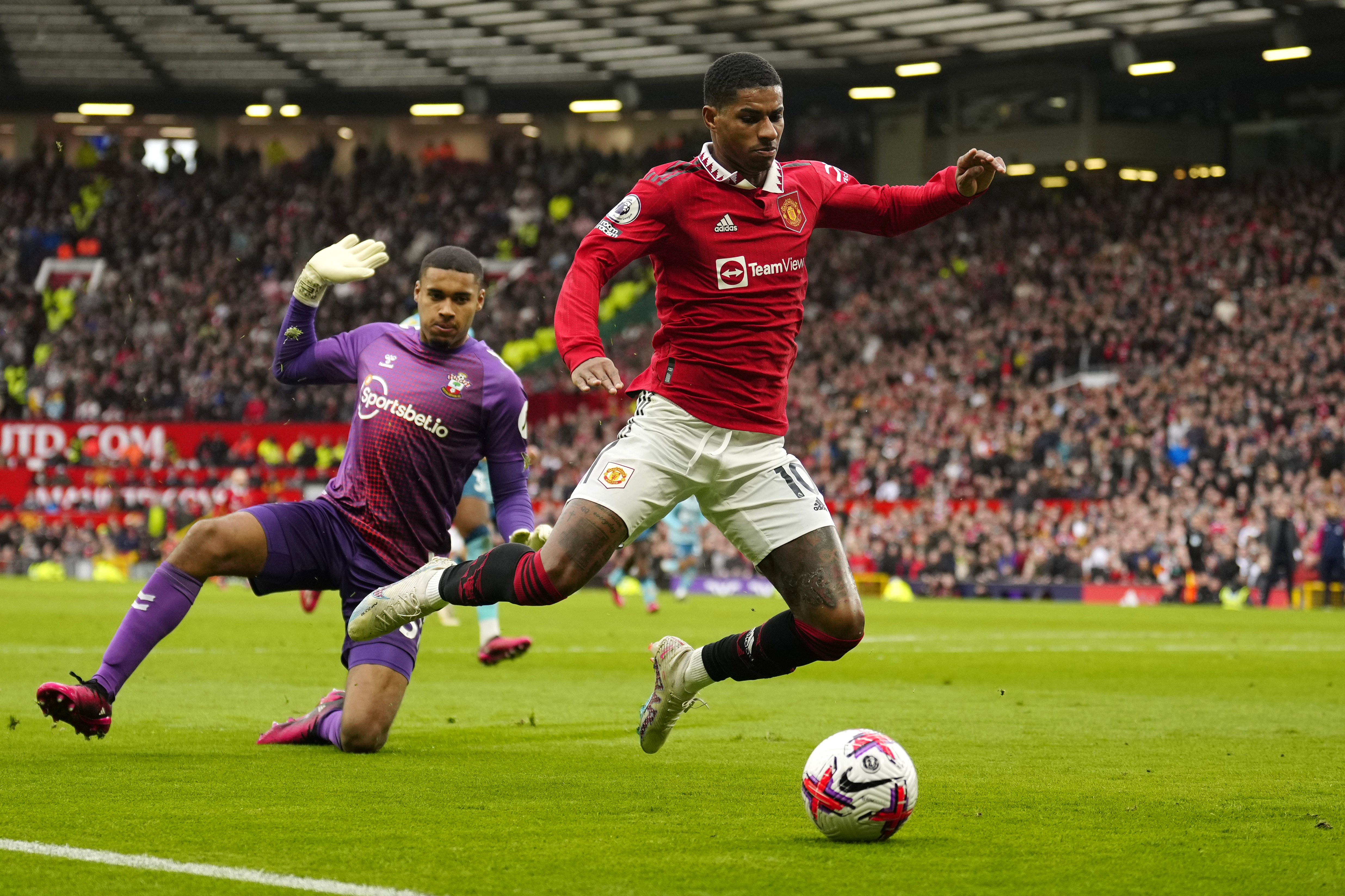 Southampton's goalkeeper Gavin Bazunu, left, and Manchester United's Marcus Rashford in action during the English Premier League soccer match between Manchester United and Southampton at Old Trafford stadium in Manchester, England, Sunday, March 12, 2023.