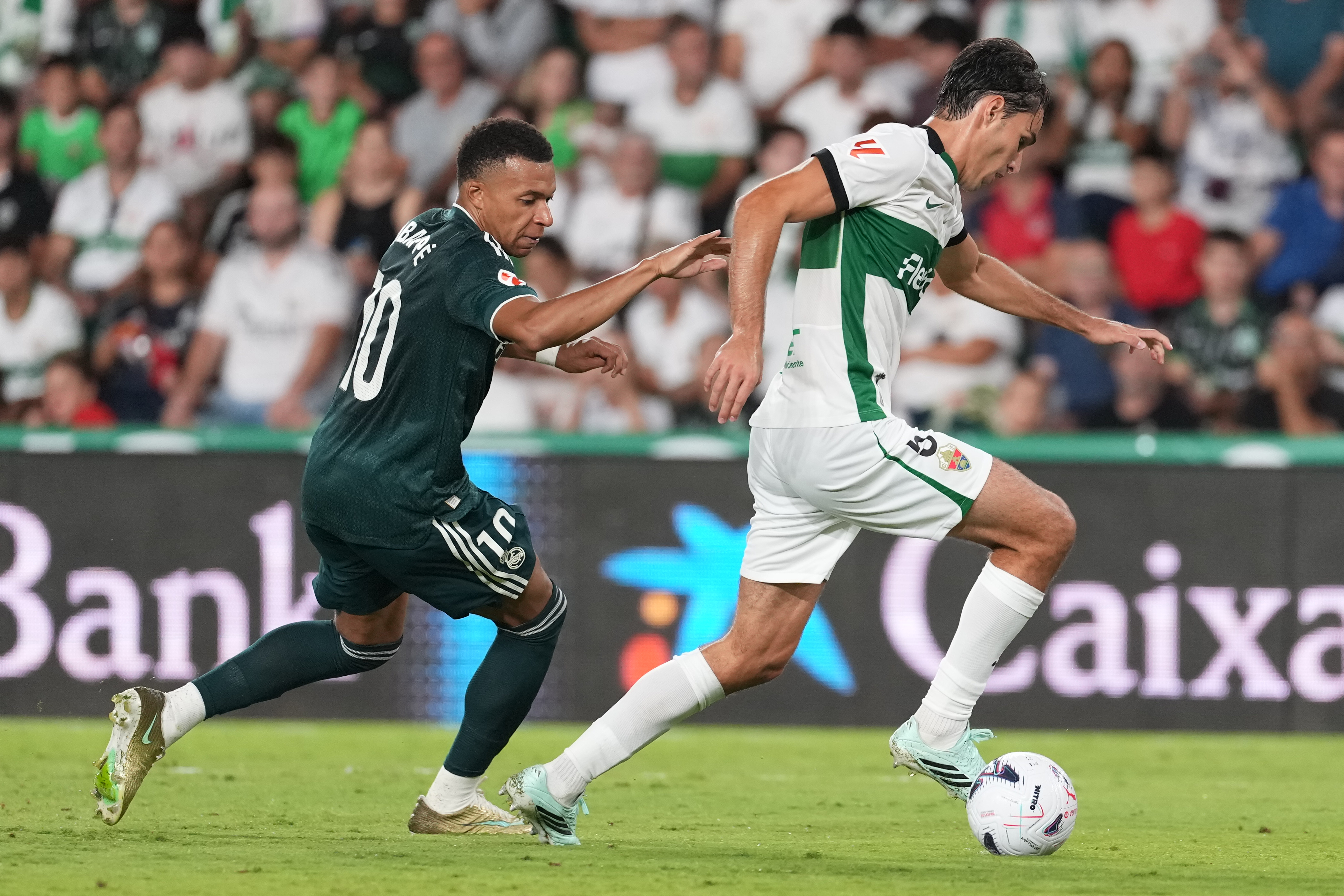 Real Madrid's Kylian Mbappe, left, challenges Elche's Federico Redondo during the Spanish La Liga soccer match between Elche and Real Madrid in Elche, Spain, Tuesday, Sept. 15, 2026. (AP Photo/Alberto Saiz)