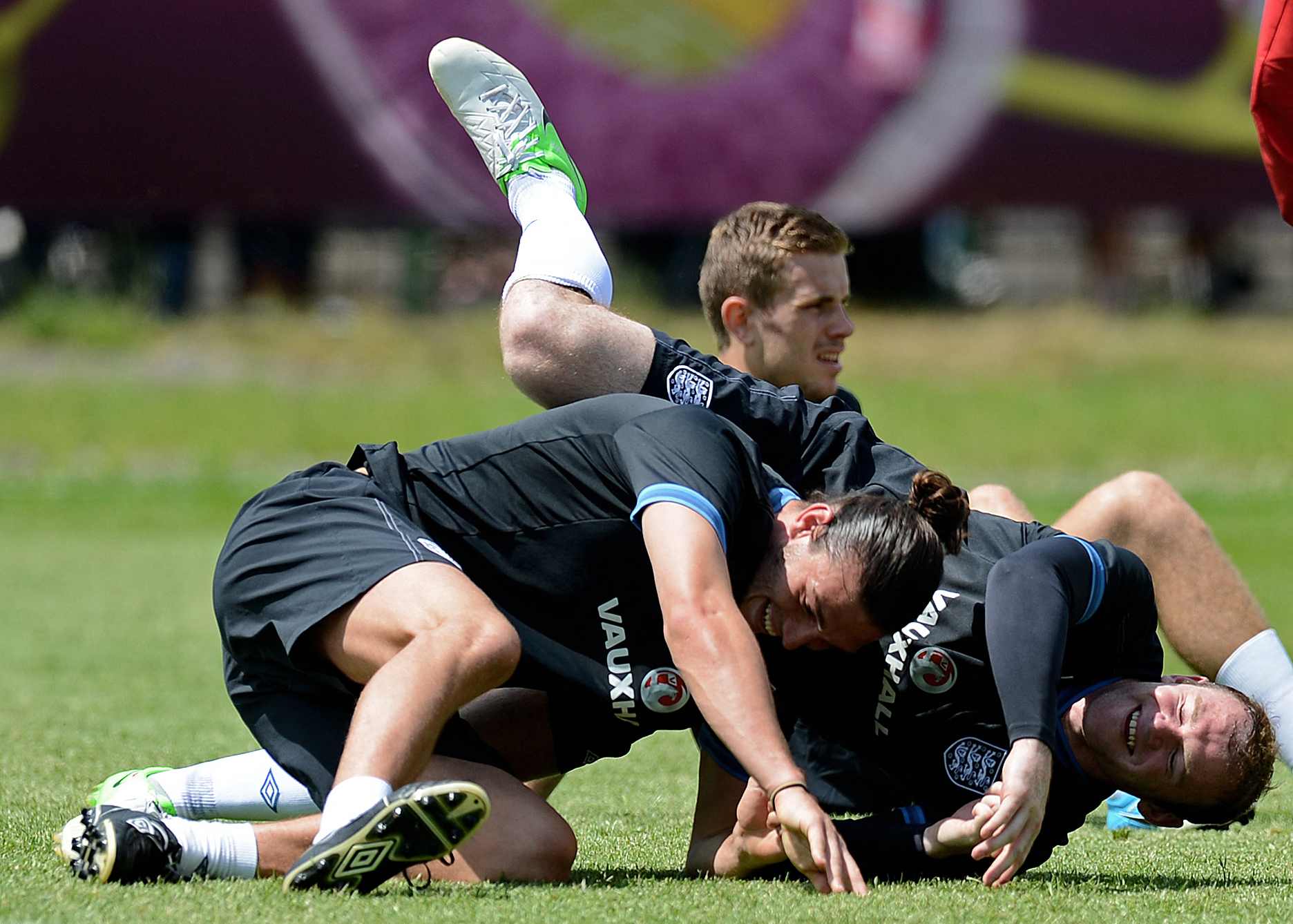 English forward Andy Carroll (L) and English forward Wayne Rooney fall over during a training session at the Suche Stawy municipal stadium in Krakow on June 8, 2012 during the Euro 2012 football Championships. AFP PHOTO/CARL DE SOUZA (Photo by CARL DE SOU