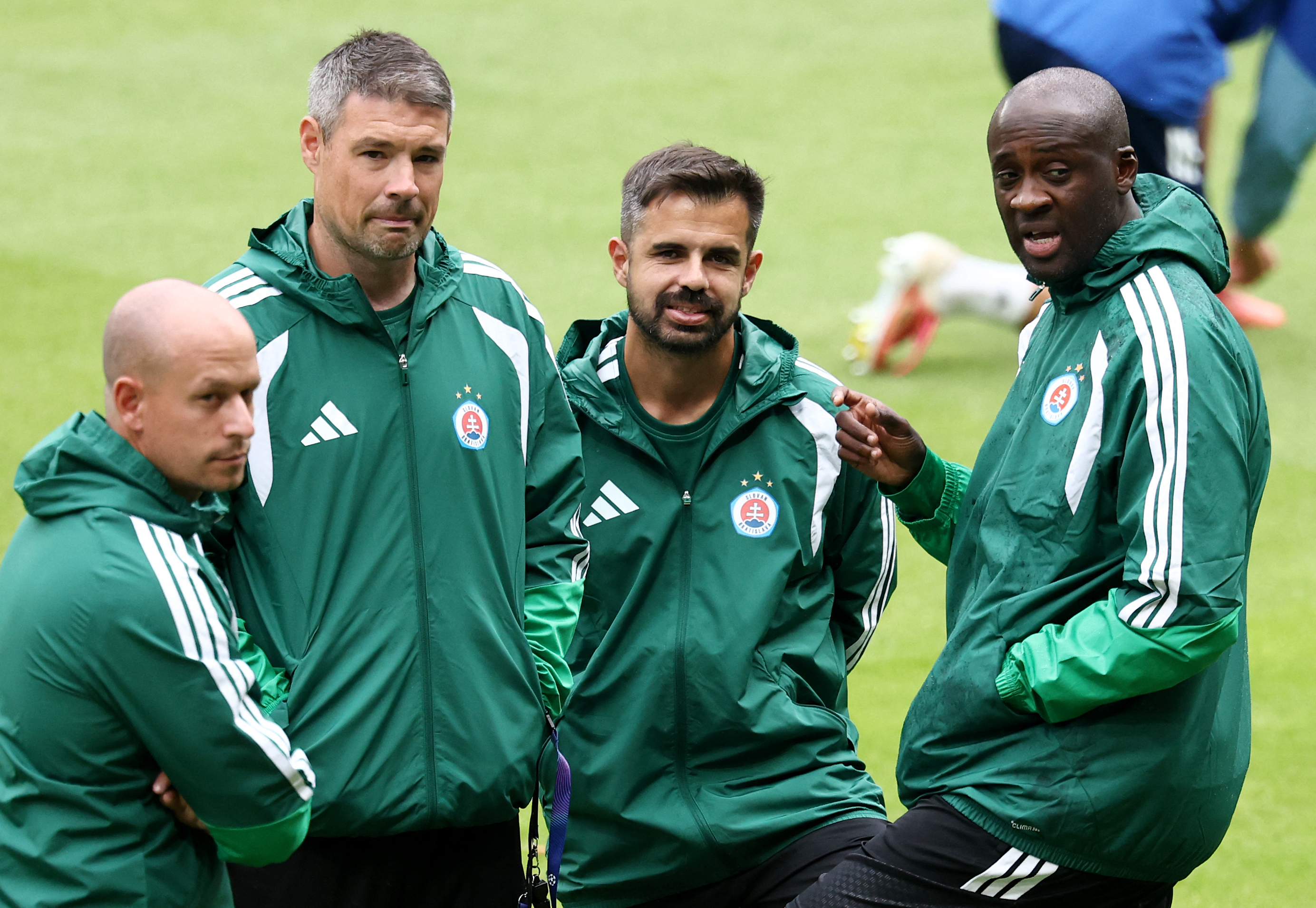 Slovan Bratislava's head coach Yaya Toure (R) speaks with Slovan Bratislava's French assistant coach Serge Costa (2R), Slovan Bratislava's Irish assistant coach Darren O'Dea (2L) and Slovan Bratislava's Slovakian assistant coach Timotej Vajdik during a tr