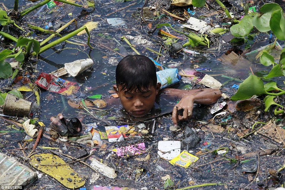 2A29C5B700000578-3148193-Scavenging_A_boy_sift_through_floating_garbage_as_he_collect_rec-a-12_1435912665073